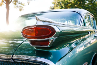 Close-up of a vintage green car's tail fin.