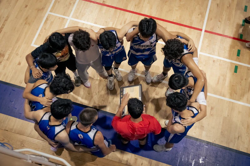 Basketball team huddles around coach on court