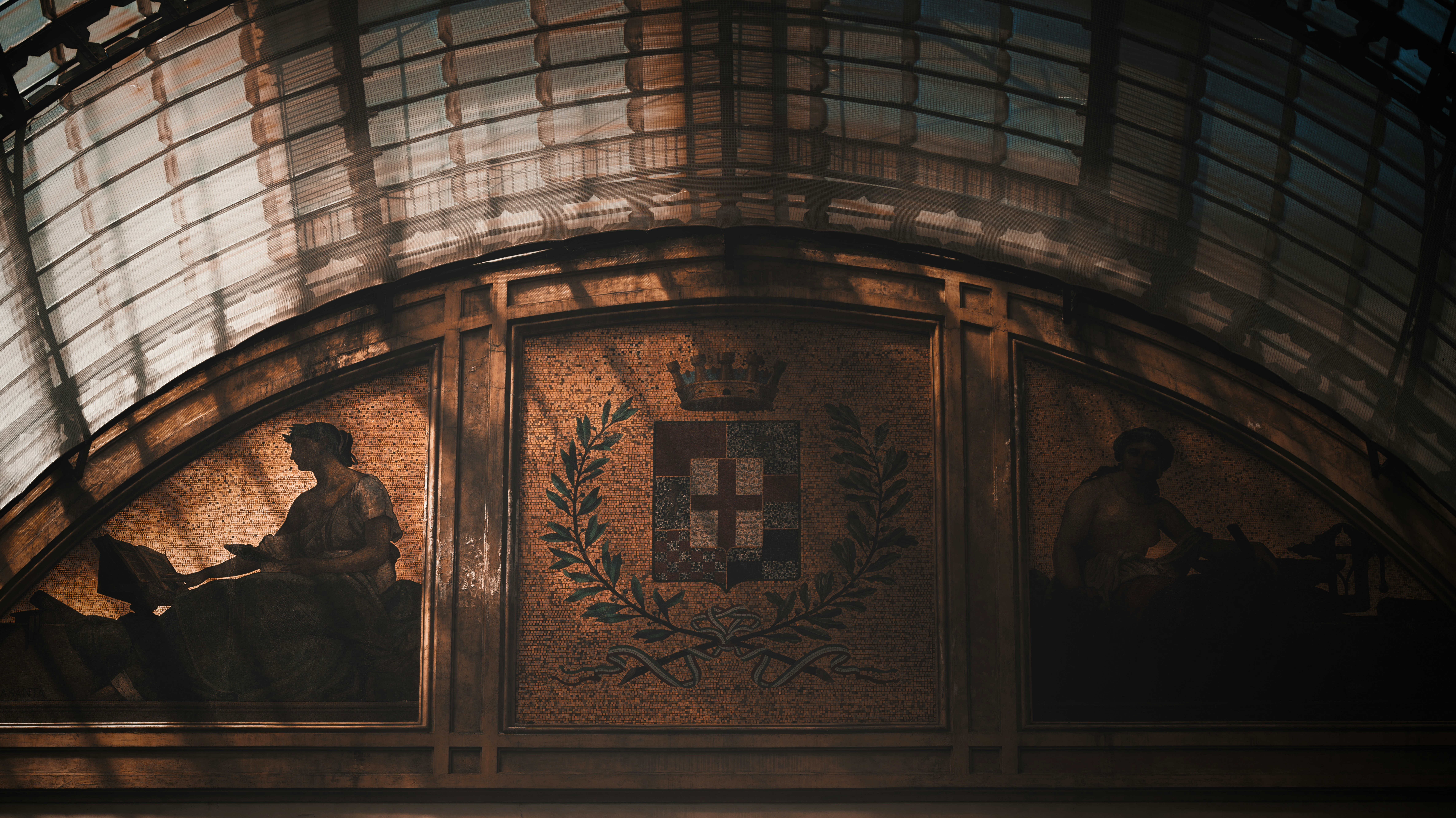 Ornate architectural detail with classical figures and emblem.