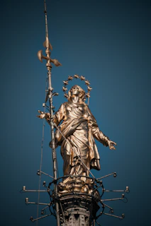 Golden statue of a woman against a blue sky