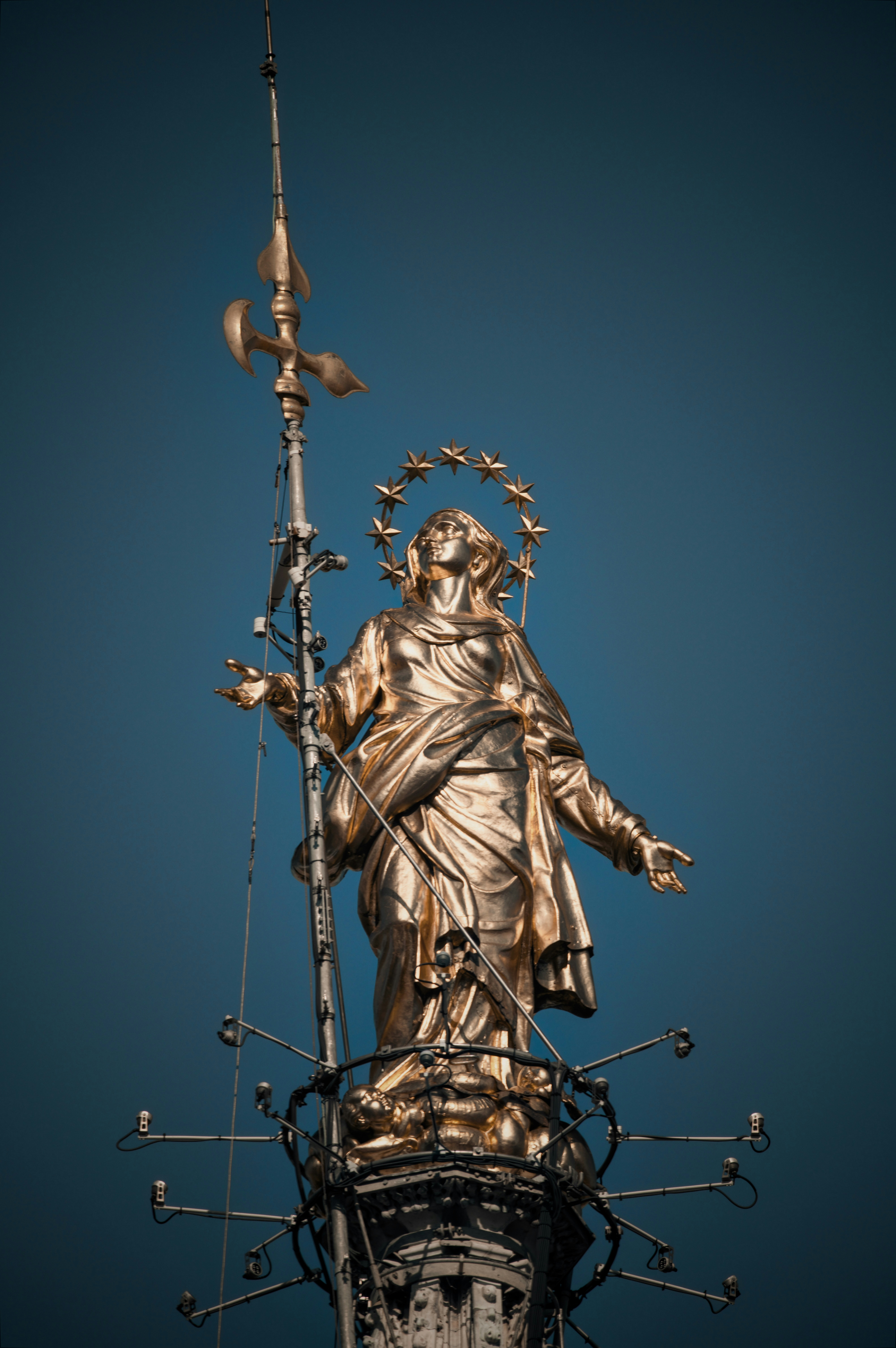 Golden statue of a woman against a blue sky