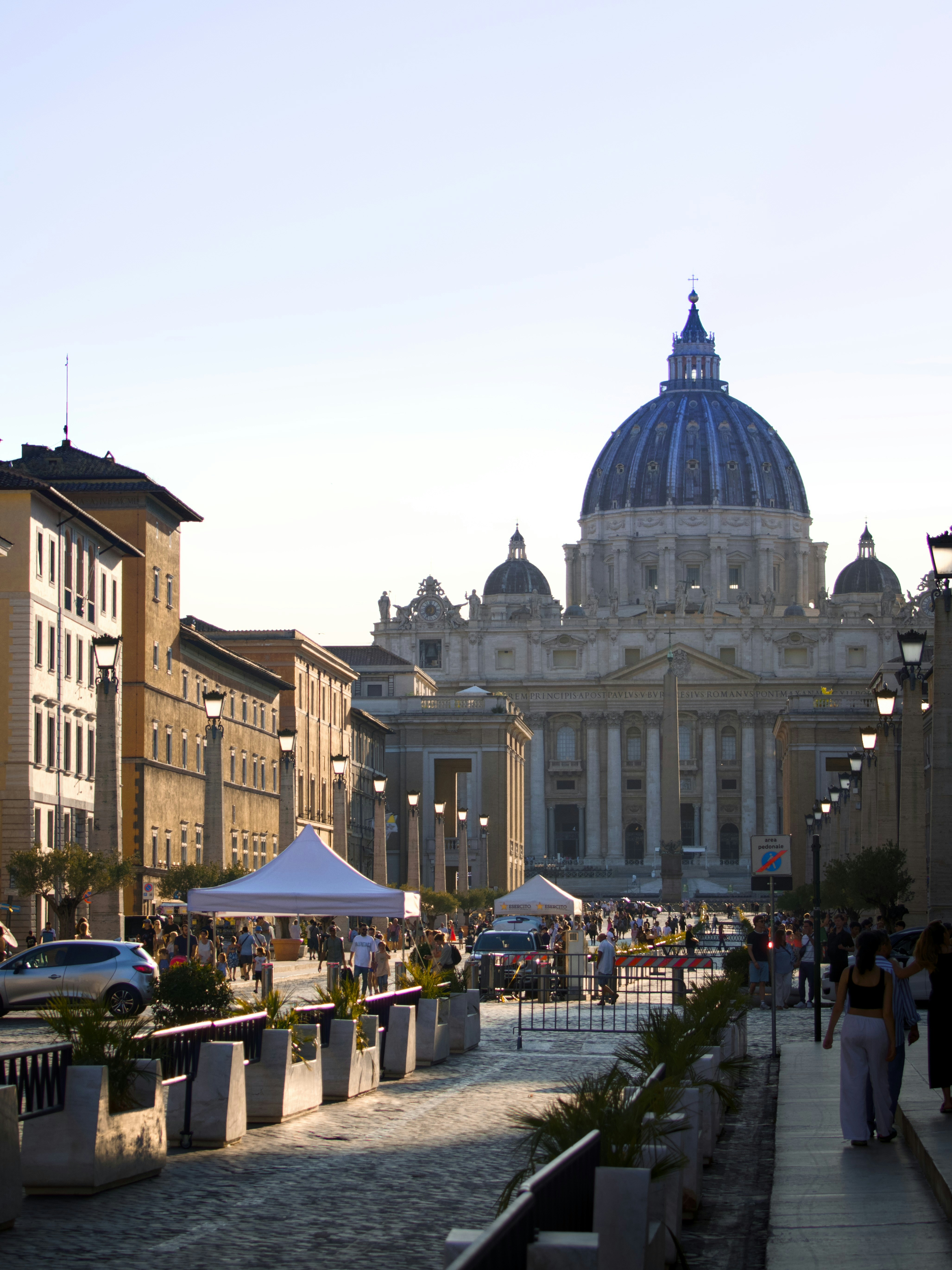 St. peter's basilica with street vendors and people walking.