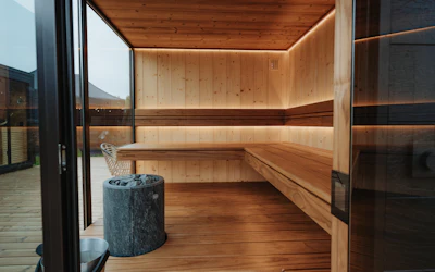 Cabine de sauna en bois ouverte par une baie sur une terrasse