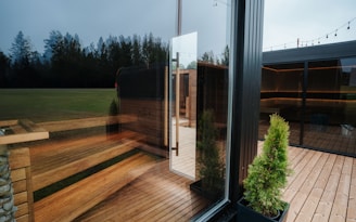Modern glass building with wooden deck and trees