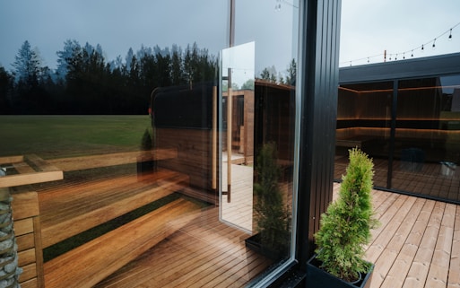 Modern glass building with wooden deck and trees