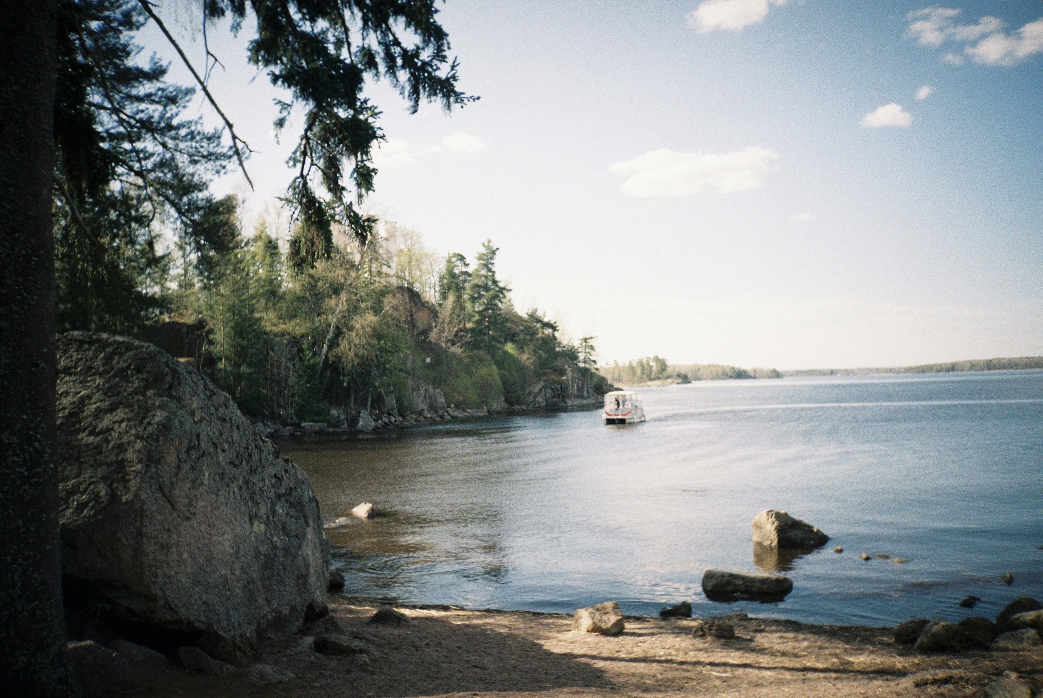 Le bateau navigue sur un large lac calme près de la rive.
