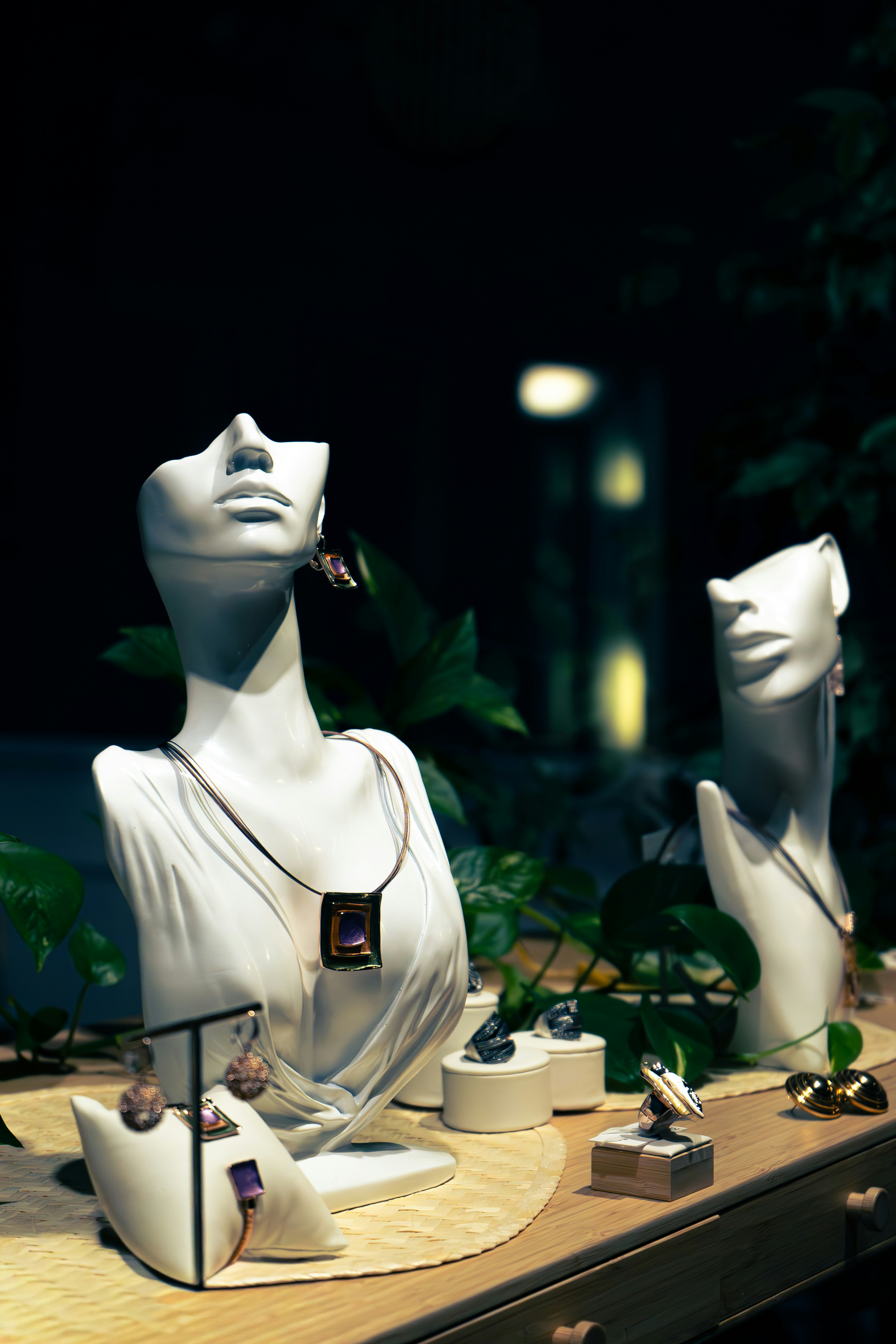 Jewelry displayed on white busts and stands