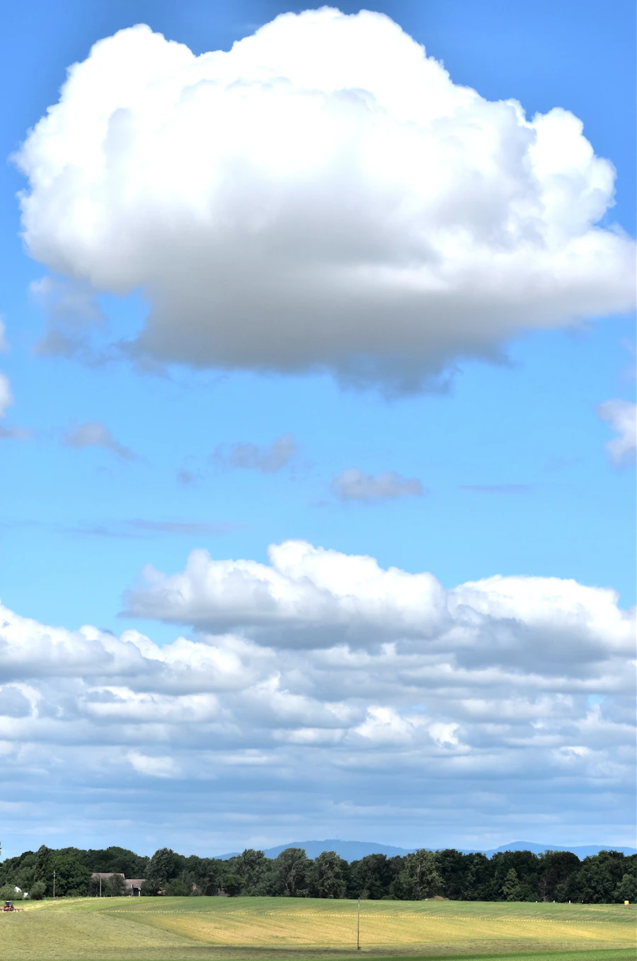 Bright white clouds over a natural green landscape