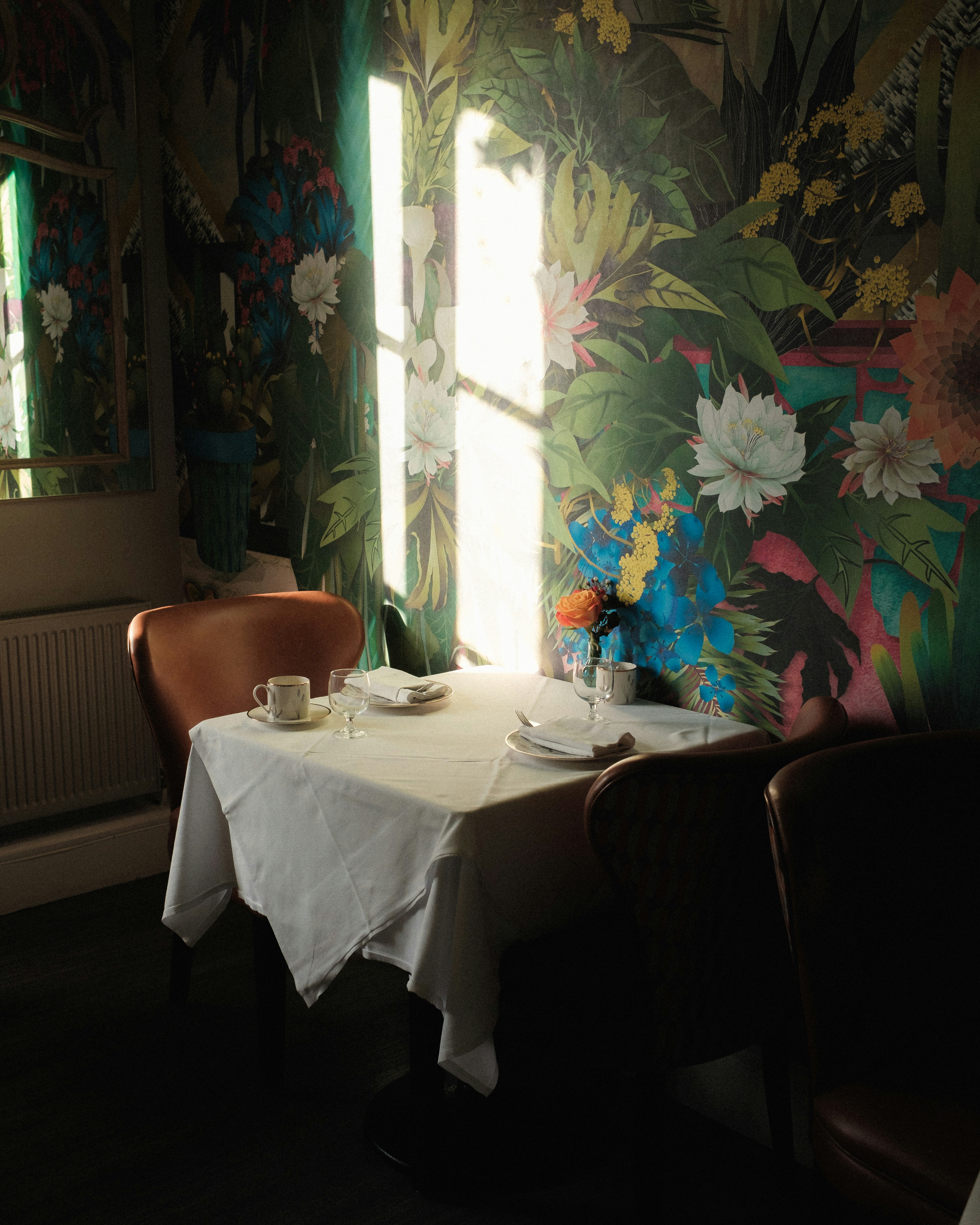Table set for two with floral wallpaper background.