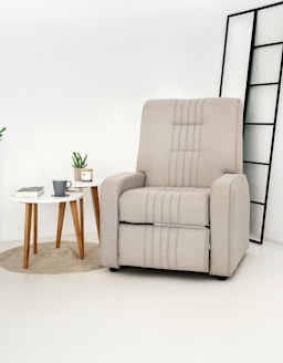 A beige recliner chair with a small side table.