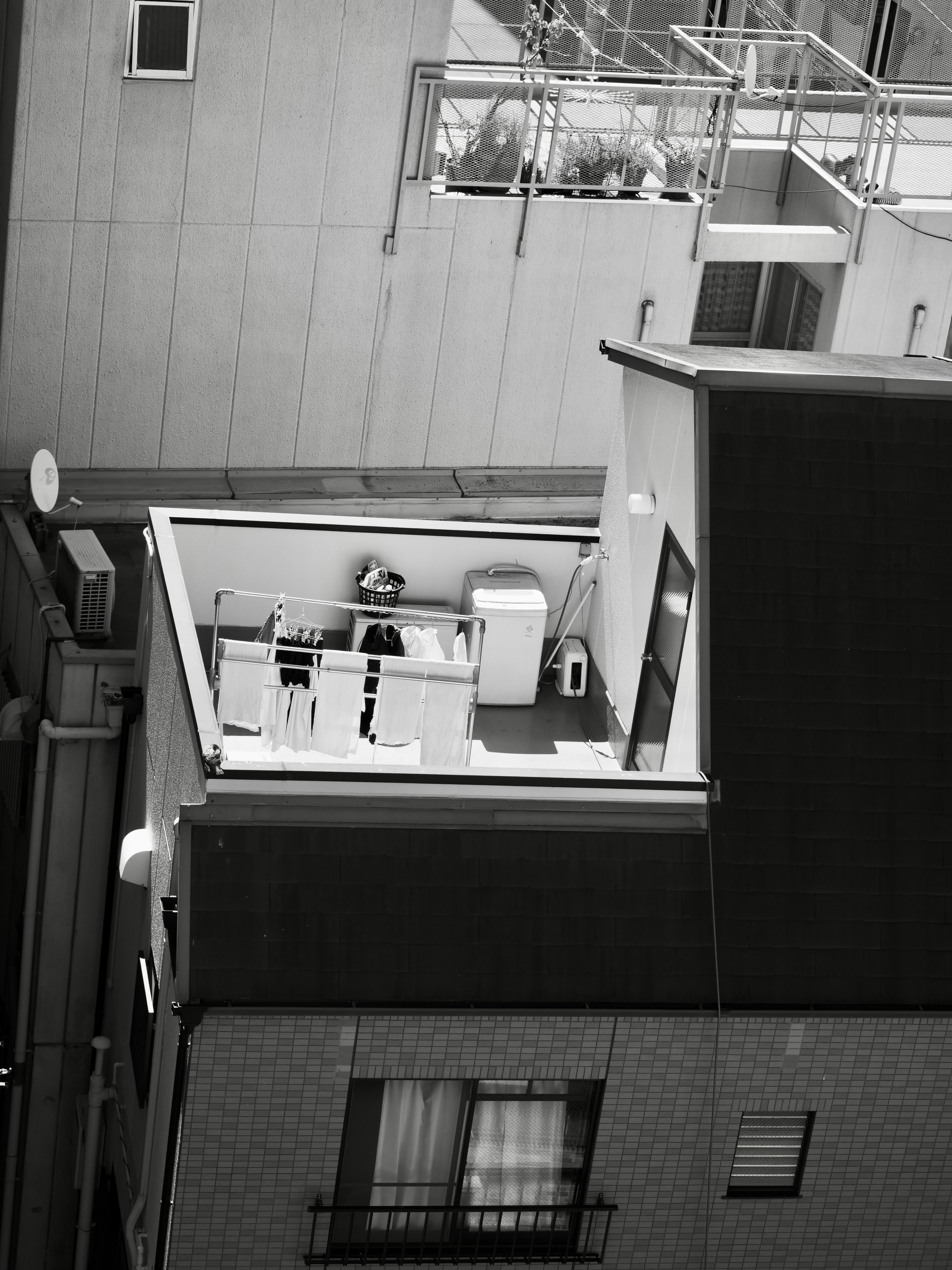 Zona de secado de ropa en la azotea con lavadora.