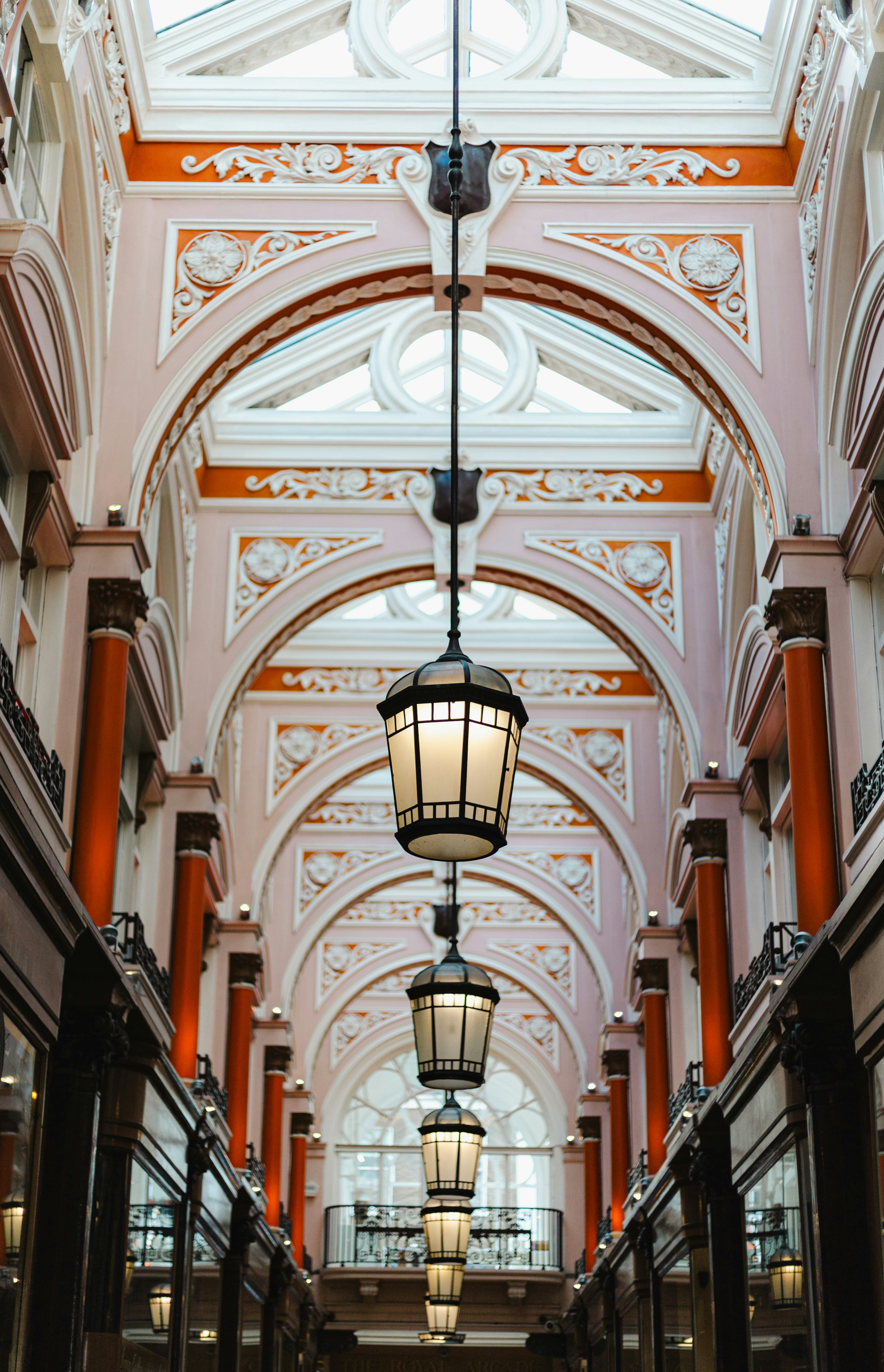 Ornate arched walkway with hanging lanterns and skylight.
