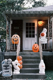 Halloween decorations on a house porch with pumpkins and ghosts
