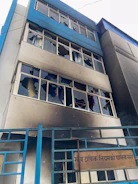 Building with shattered windows and smoke damage