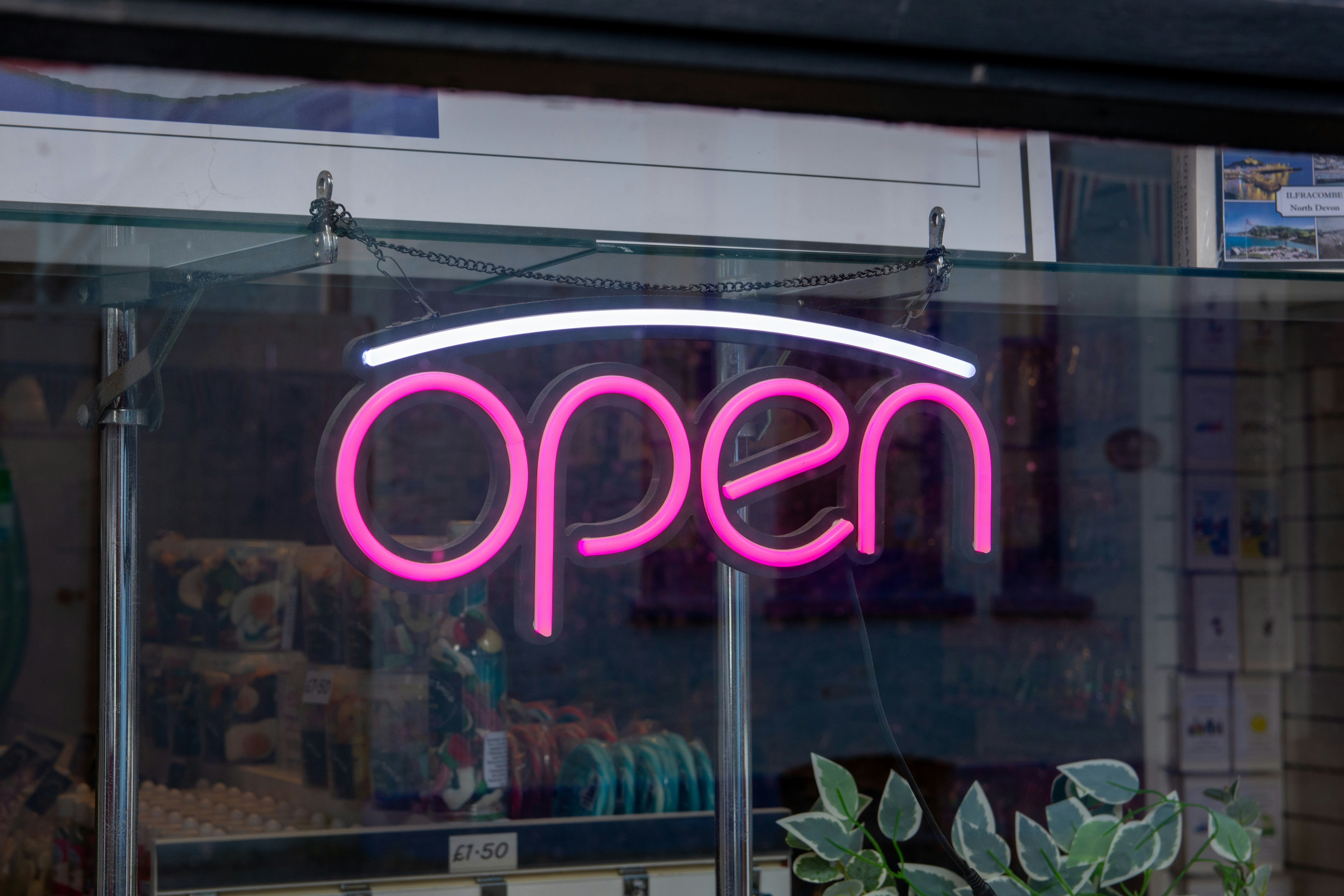 Neon open sign glows pink in window