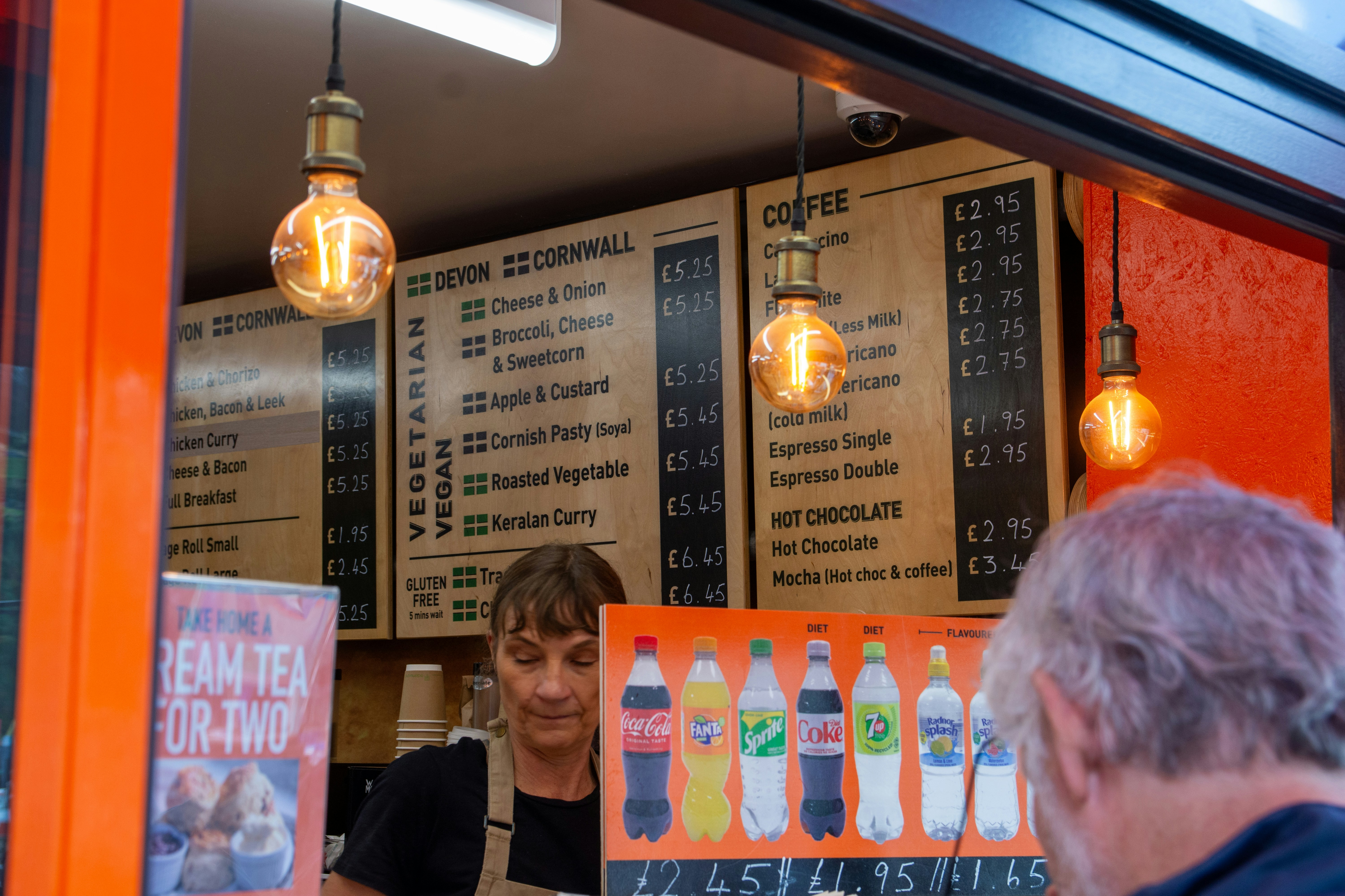 Staff serving drinks at a food stall.