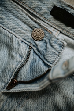 Close-up of light blue denim jeans with zipper.