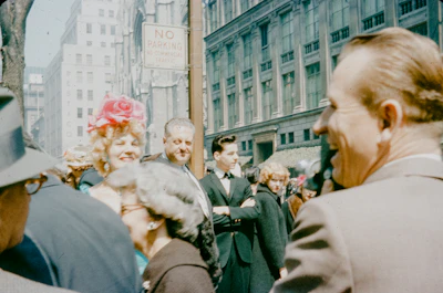 People gathered on a city street with buildings.