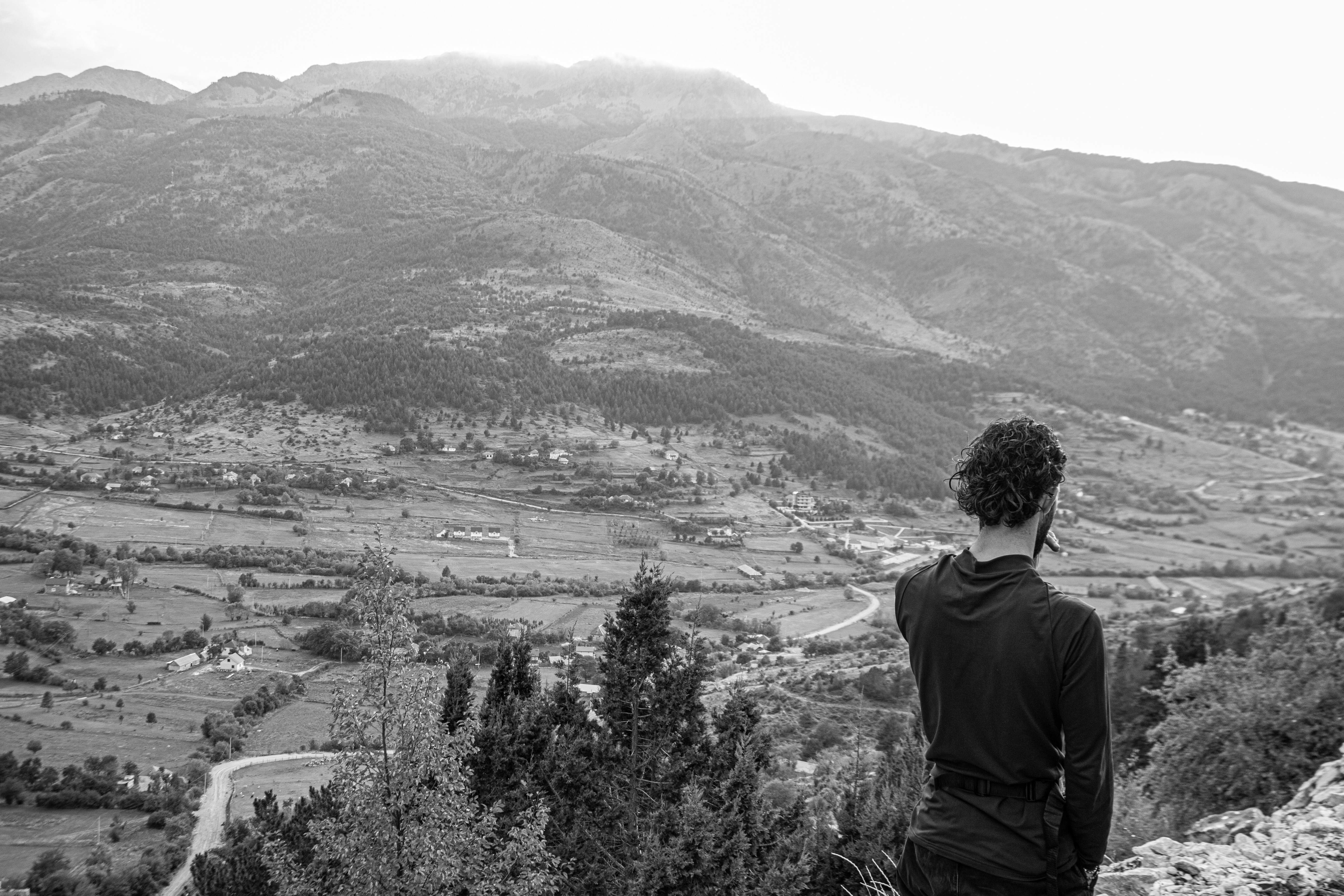 Man looking out over a vast valley landscape.