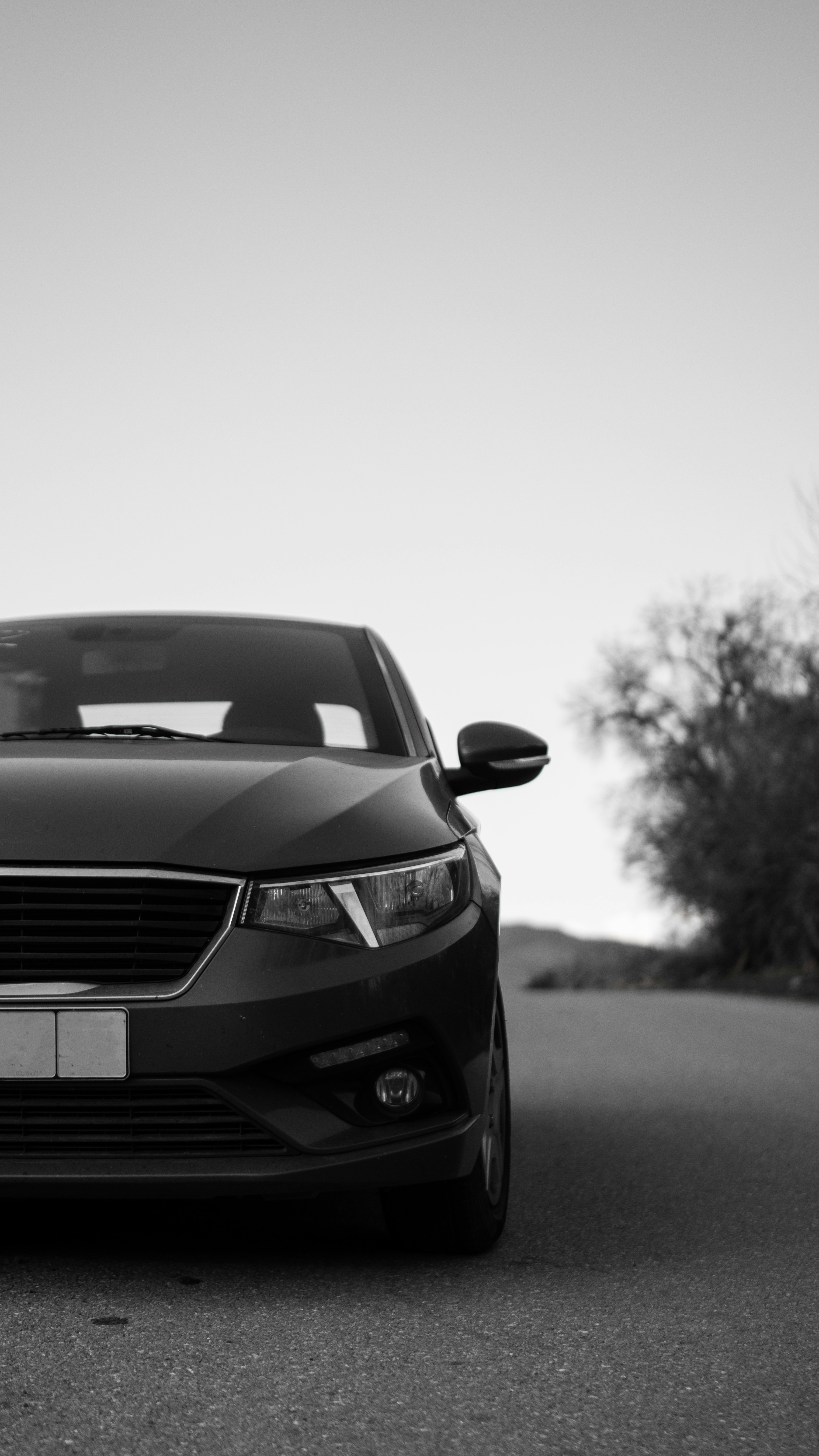 Vista frontale di un'auto scura su una strada.