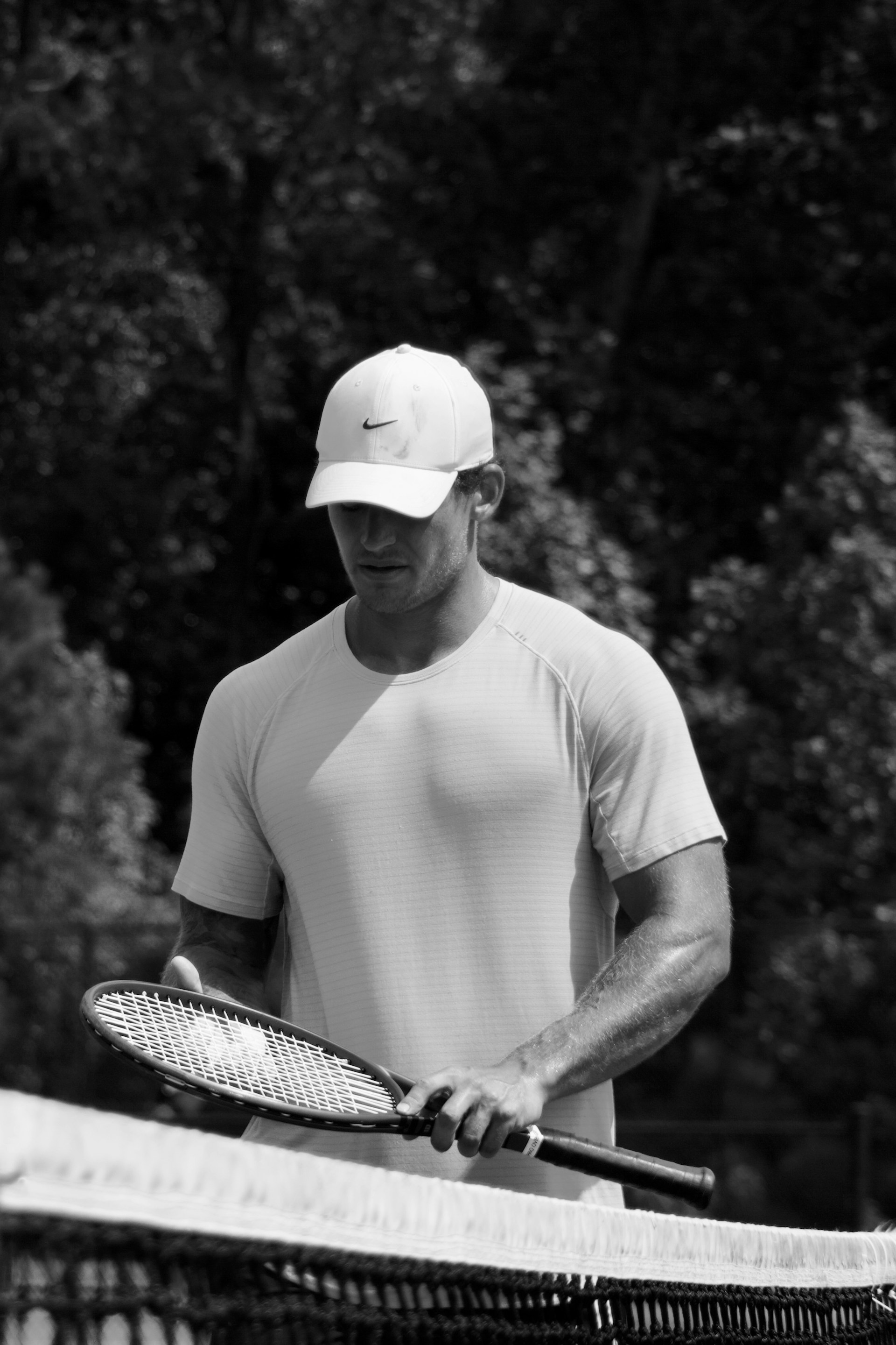 Man in hat holding tennis racket on court