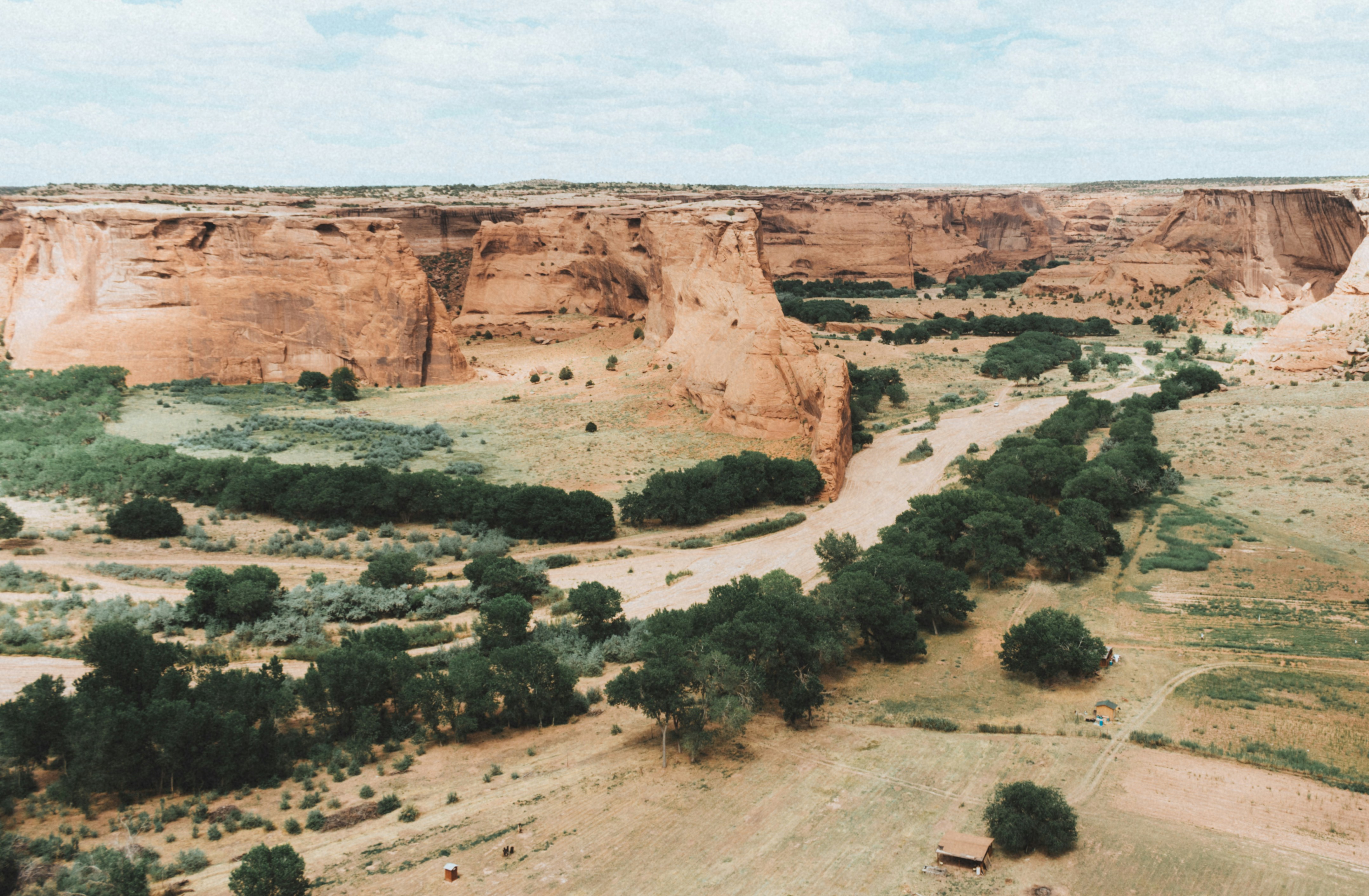 Canyon with a river and green trees below.