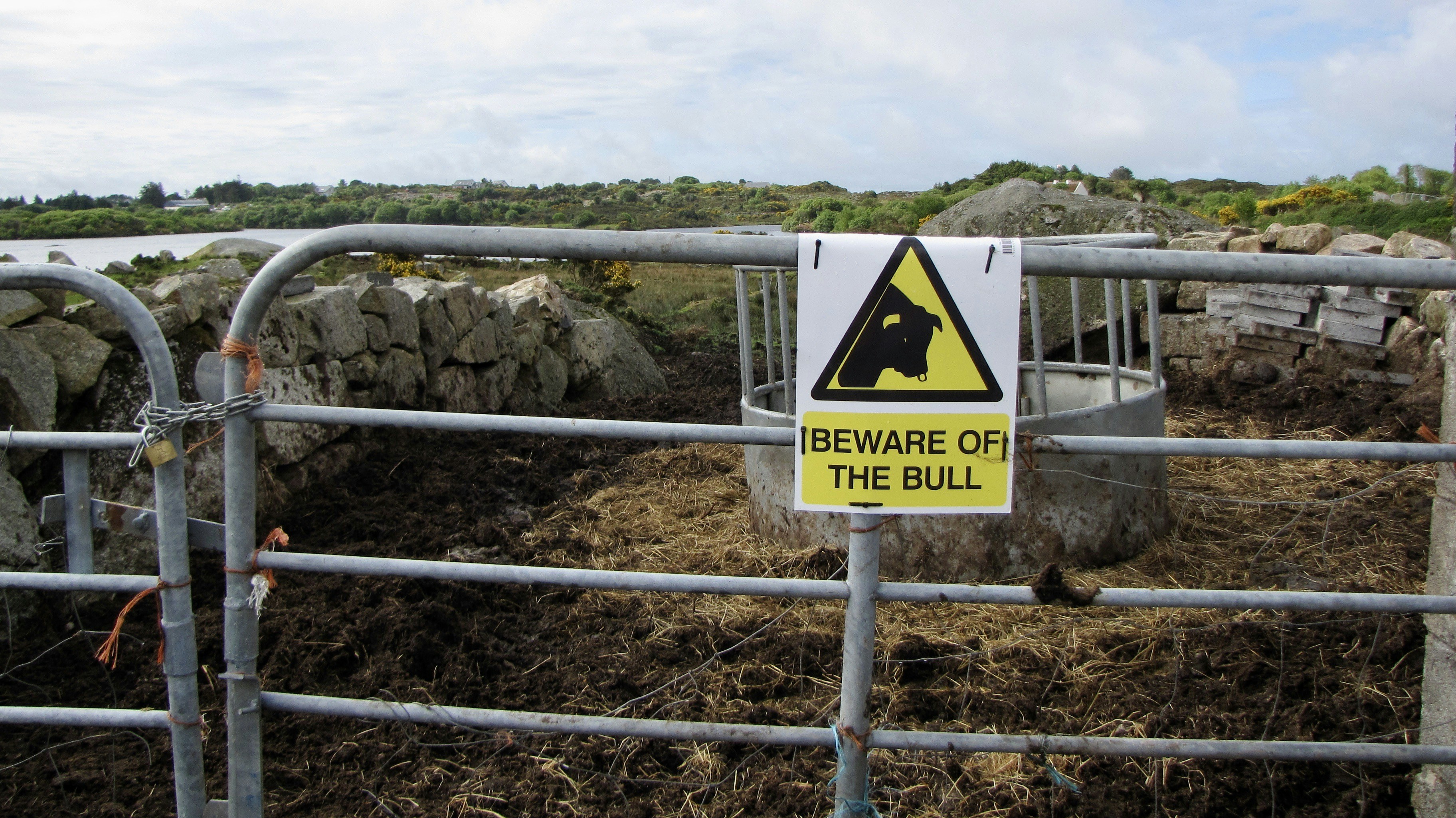 Beware of the bull sign on metal fence.