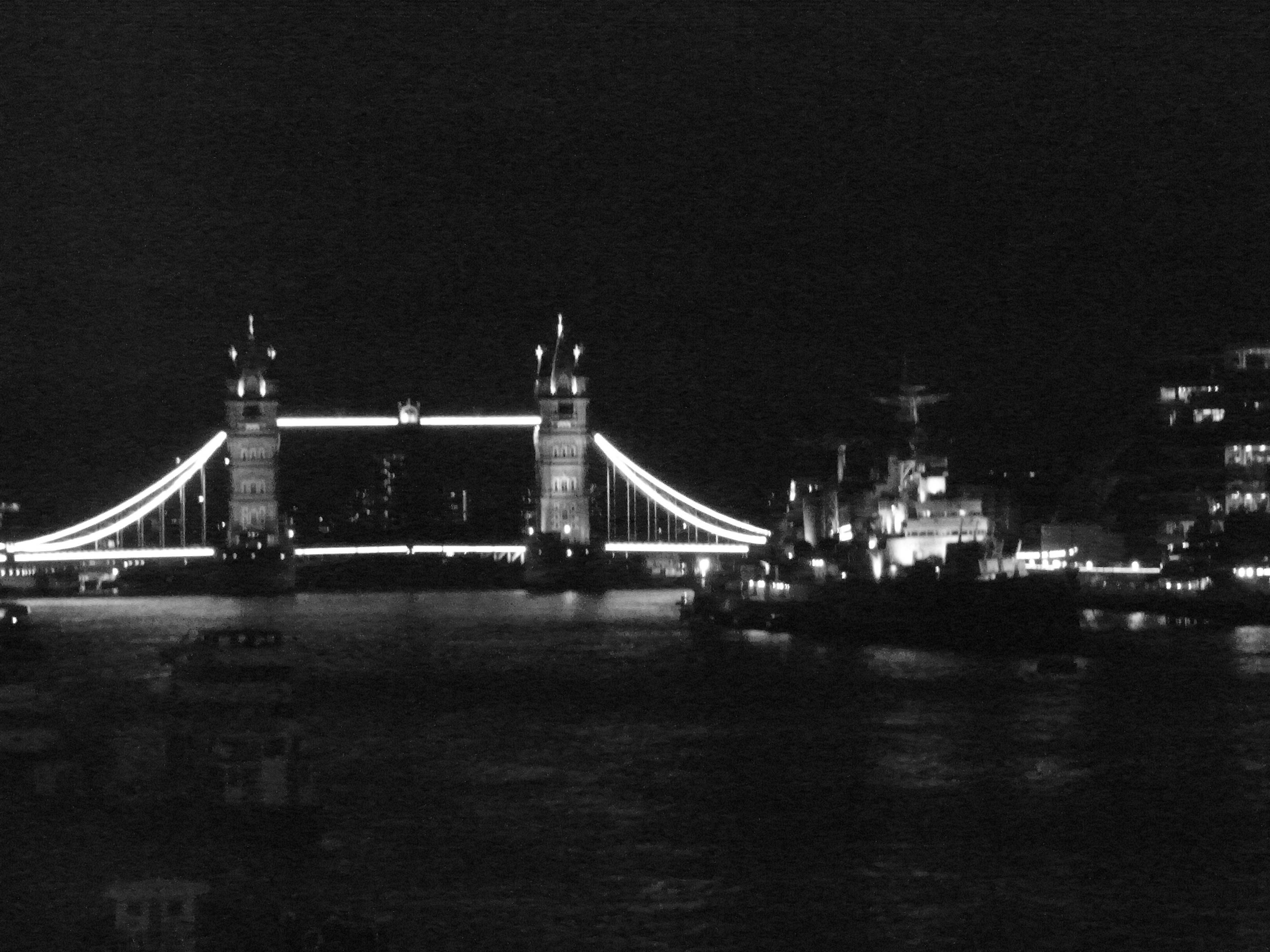 Tower bridge illuminated at night over the thames river.