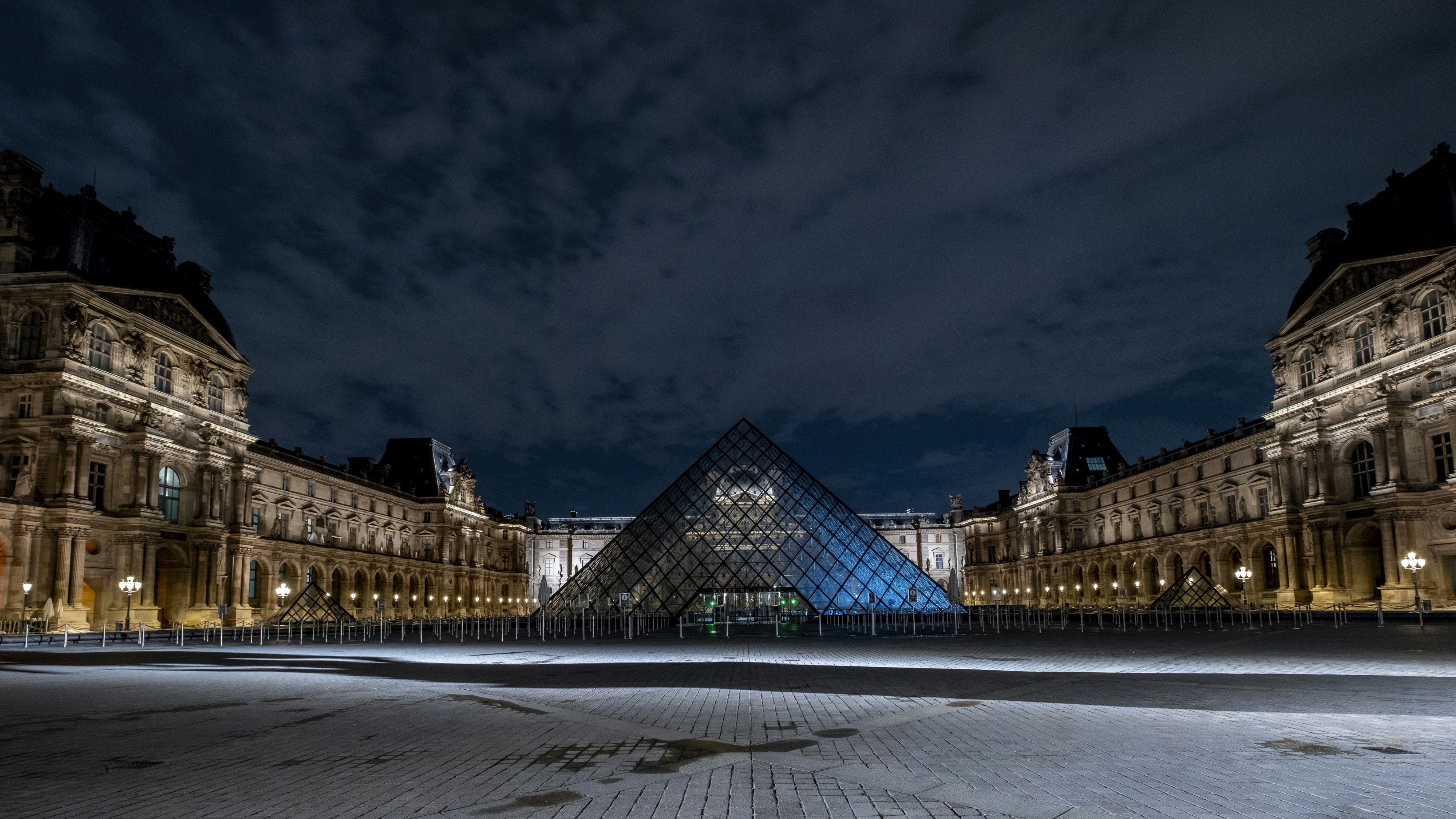 Die Lamellenpyramide, die nachts unter einem dunklen Himmel beleuchtet wird.
