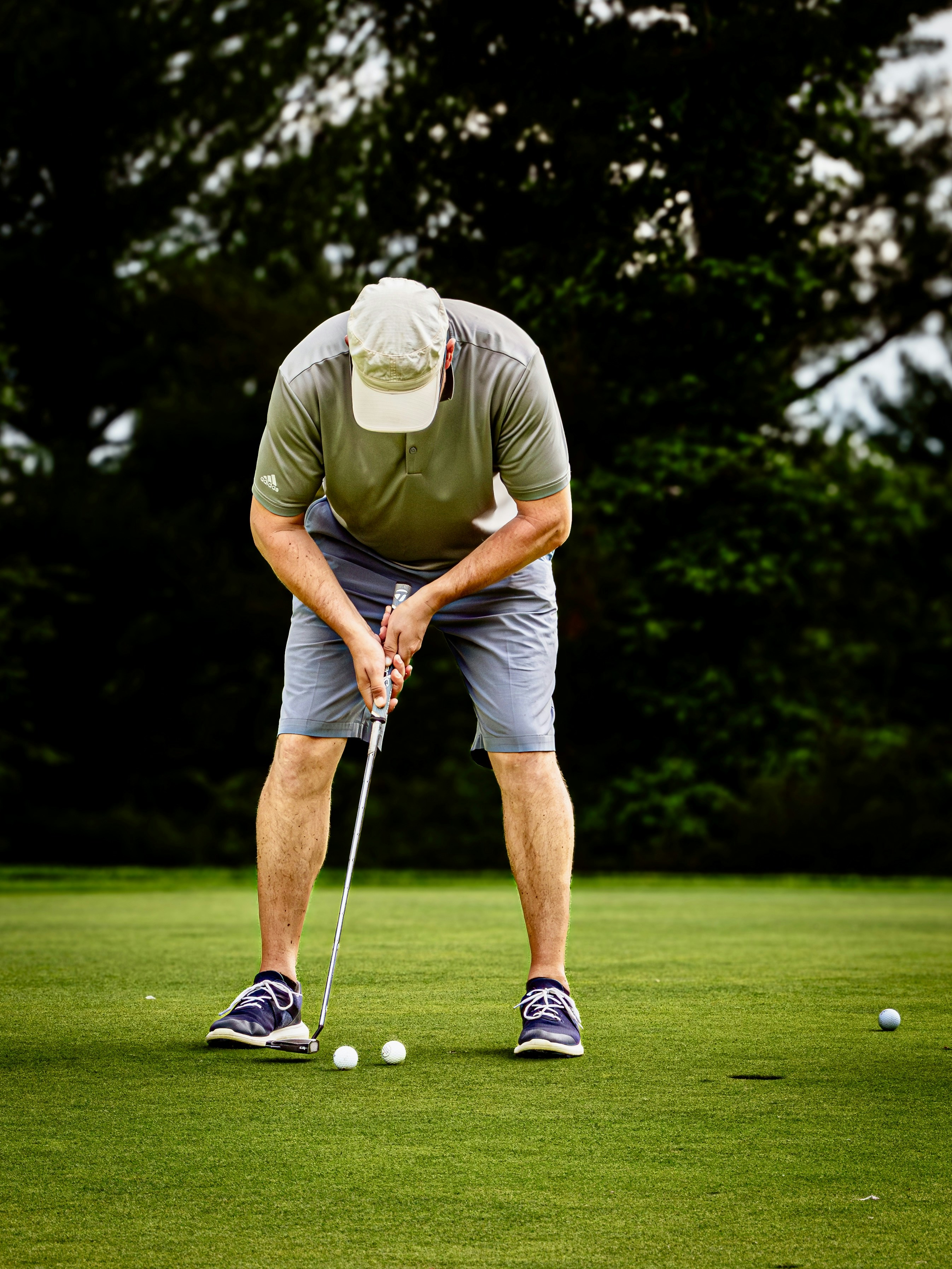 ゴルファーが3つのボールでグリーンにパッティングする