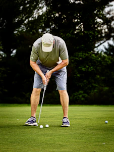 Golfer putting on a green with three balls