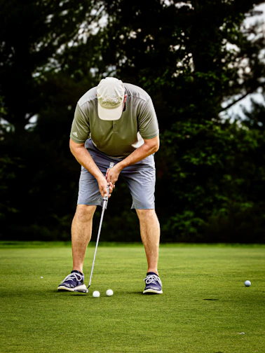 Golfer putting on a green with three balls