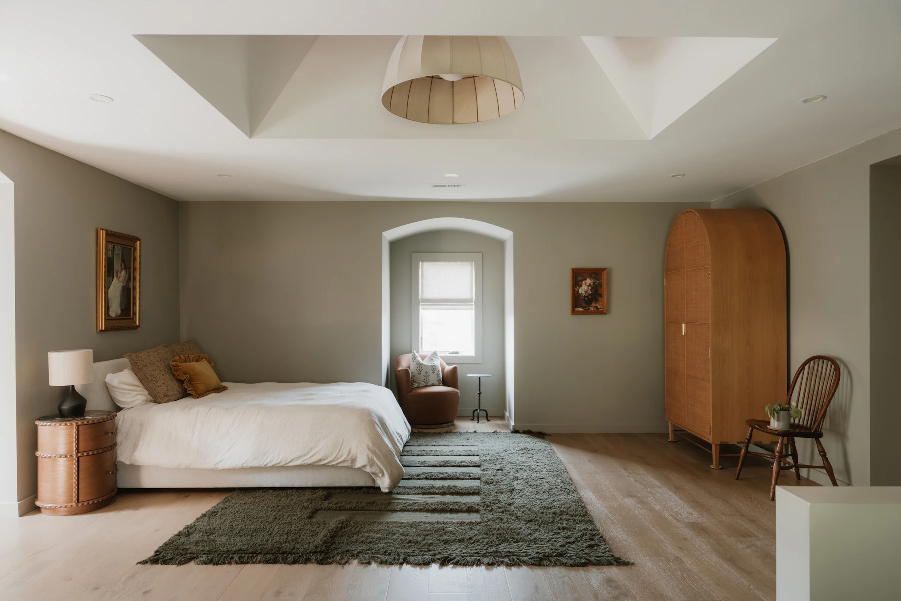 Calm neutral bedroom with upholstered bed, wooden furniture and soft natural light