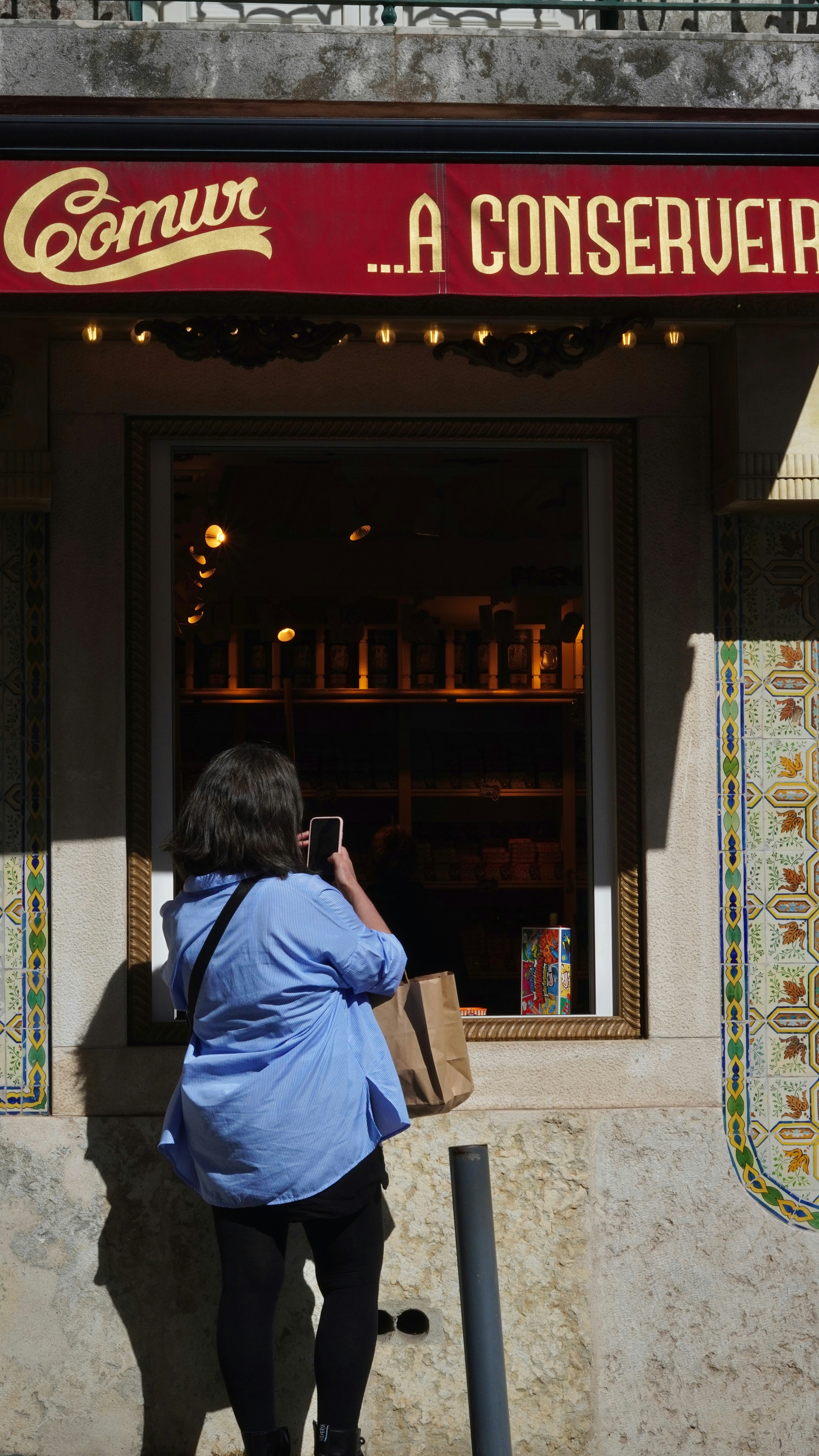 Woman taking a picture of a shop window