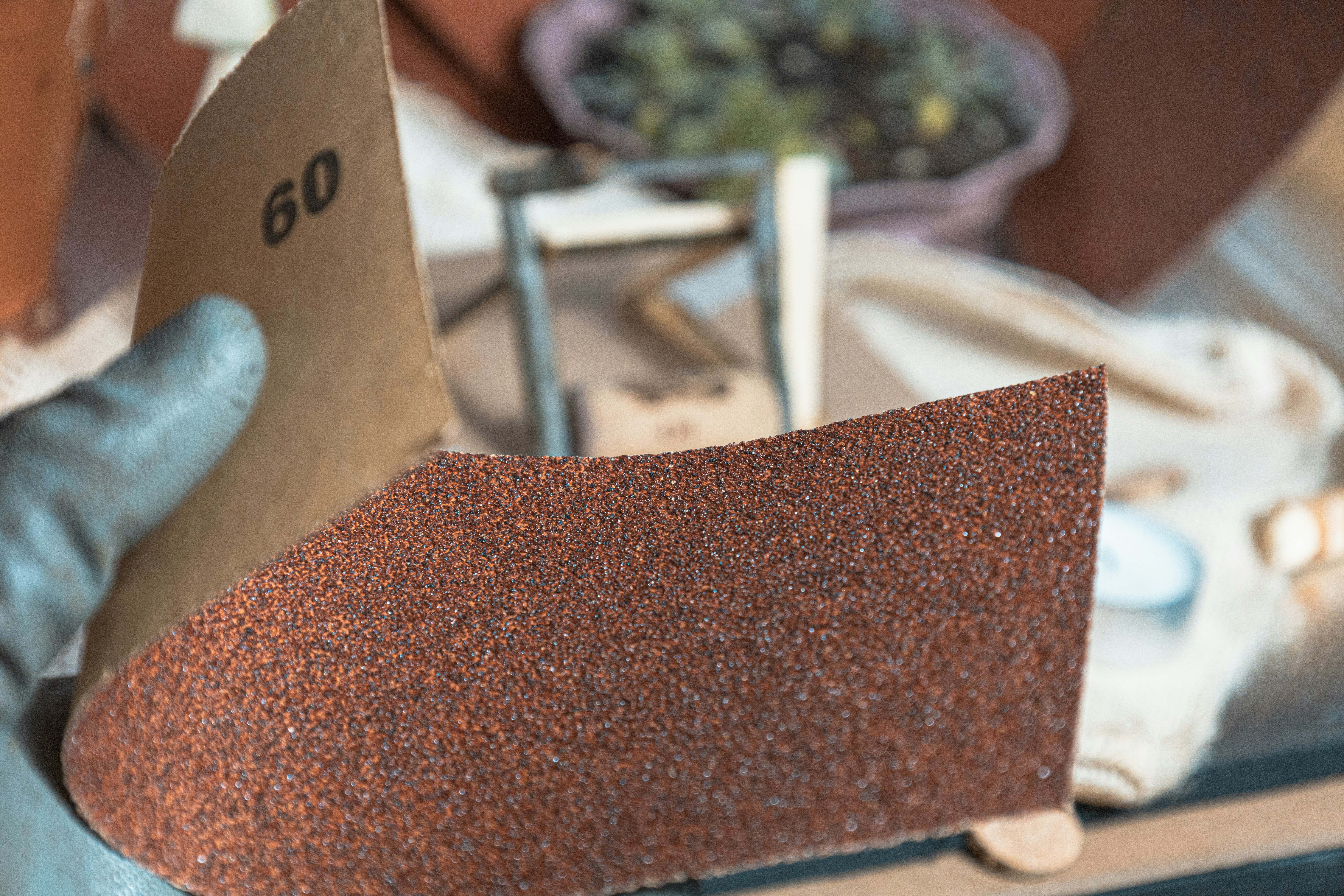 Hand holding sandpaper with grit number 60