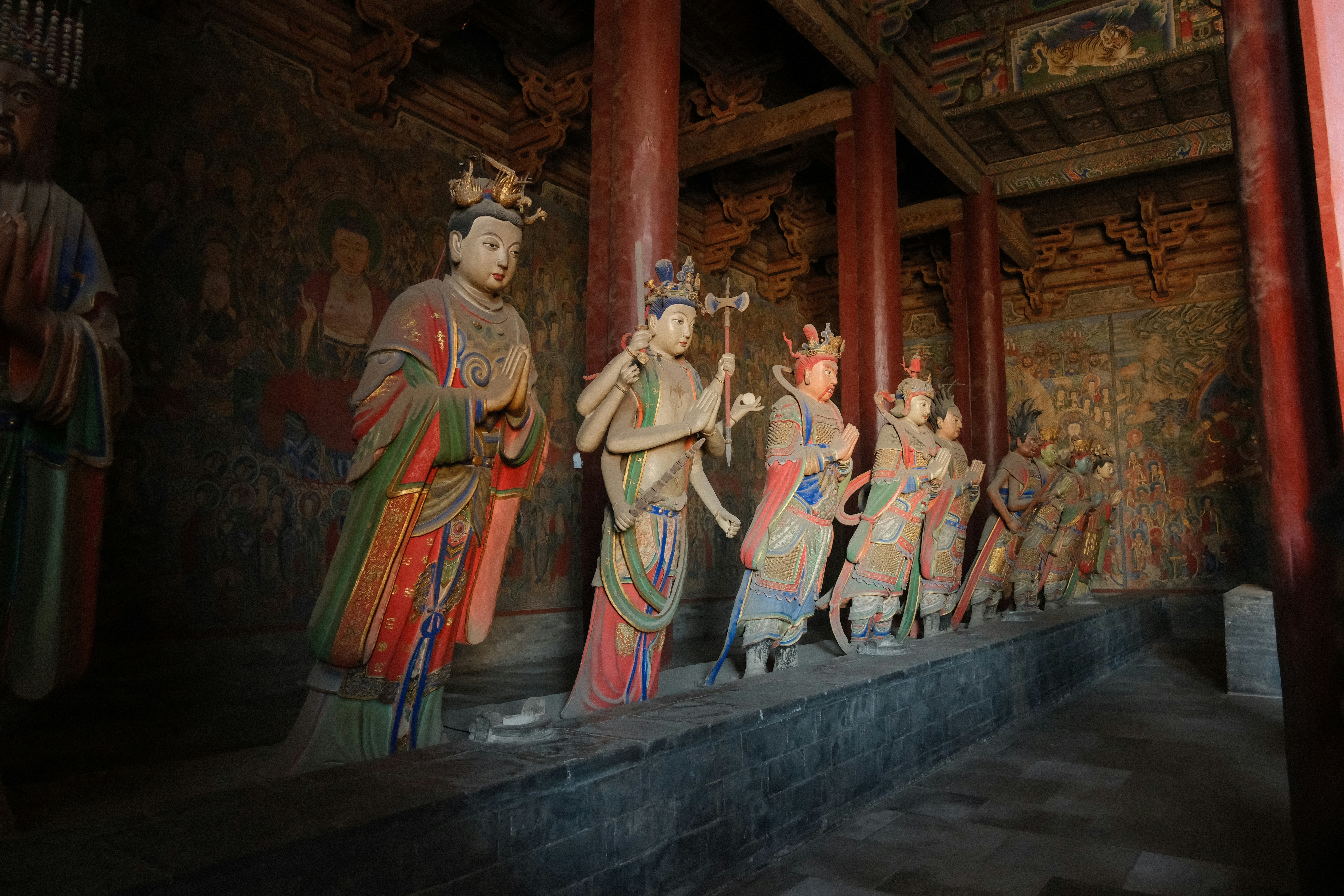 Row of colorful ancient statues in a temple
