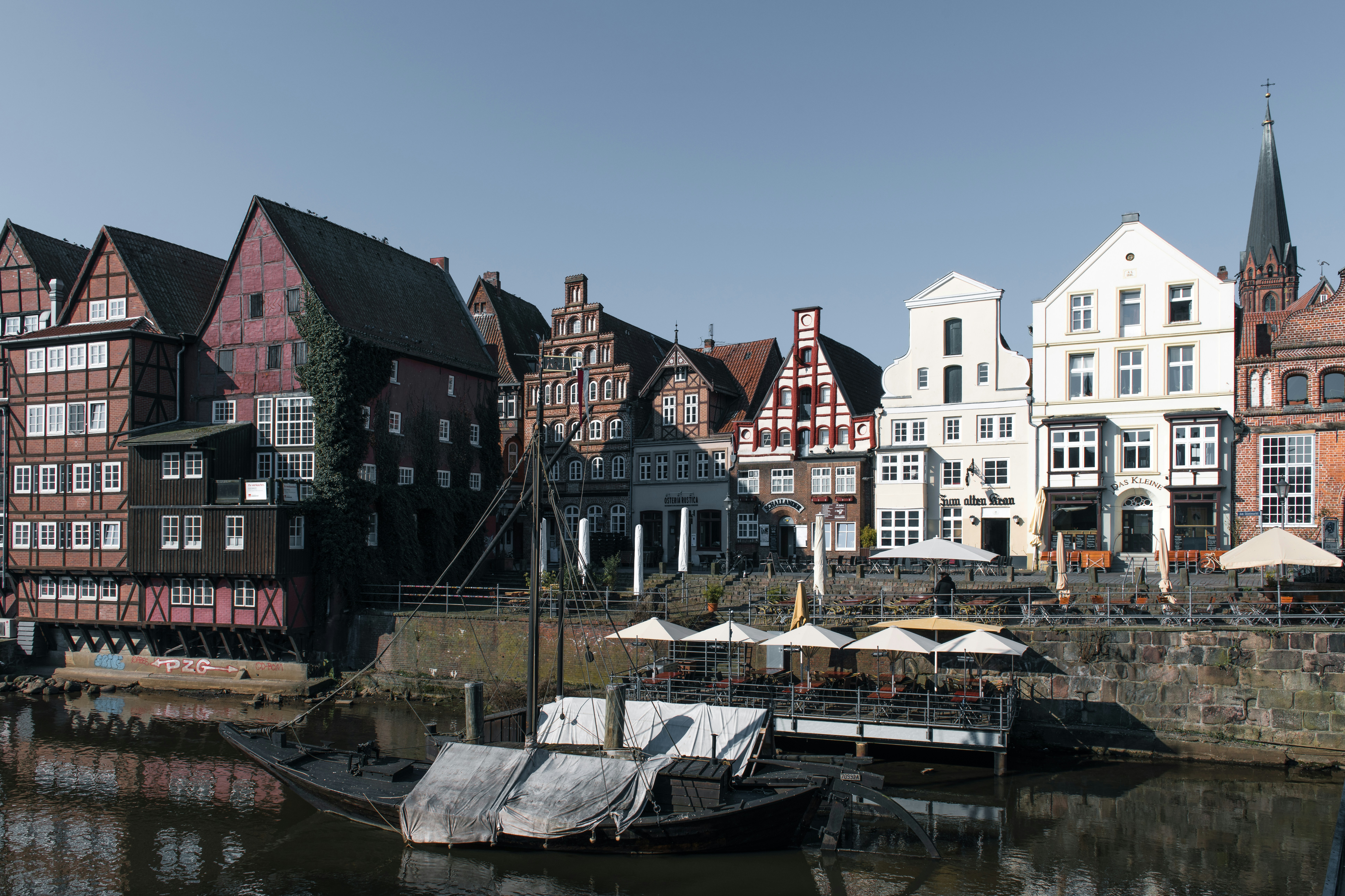 Historic buildings line a canal with a moored boat.