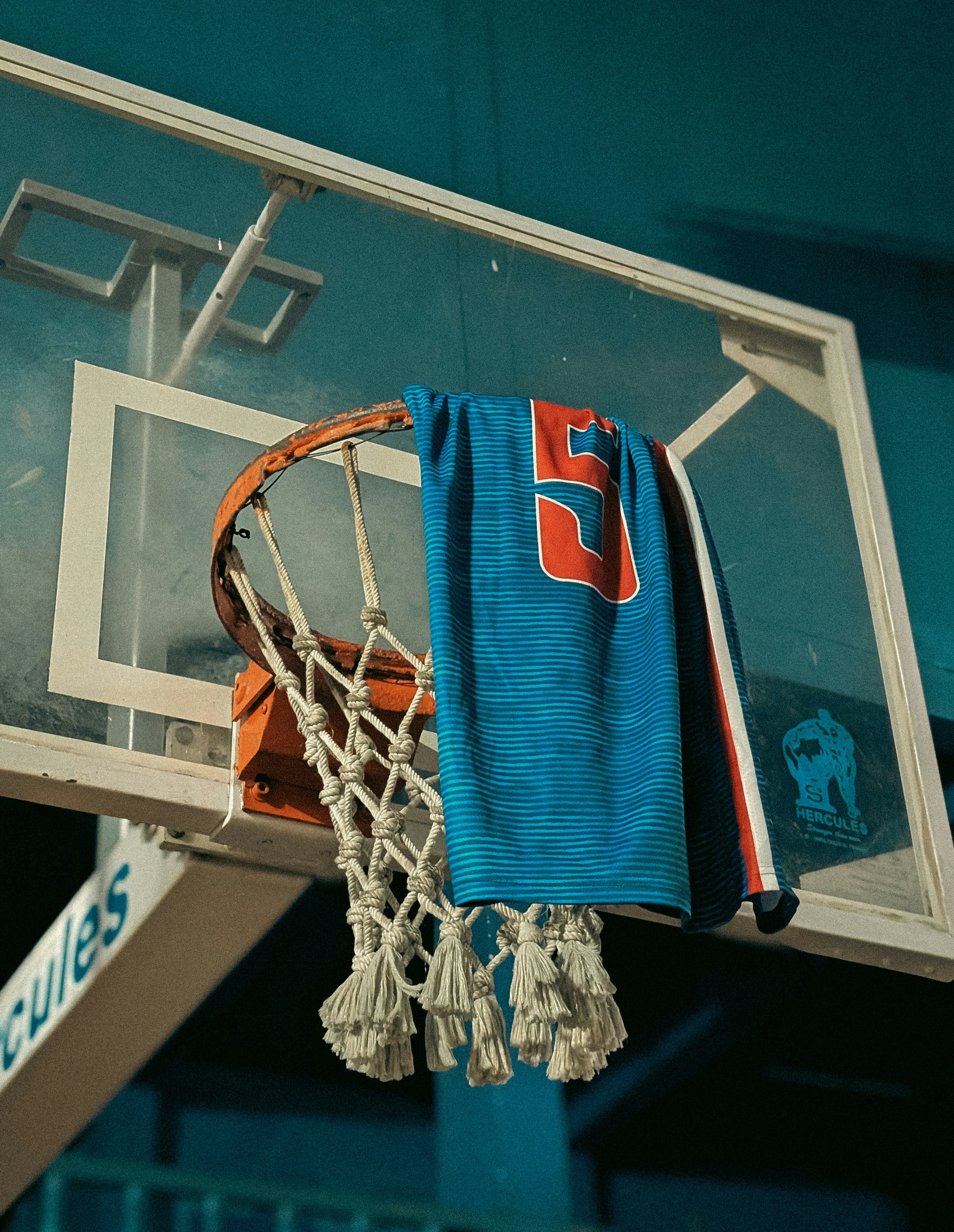 Blue towel with number 5 hangs on basketball hoop