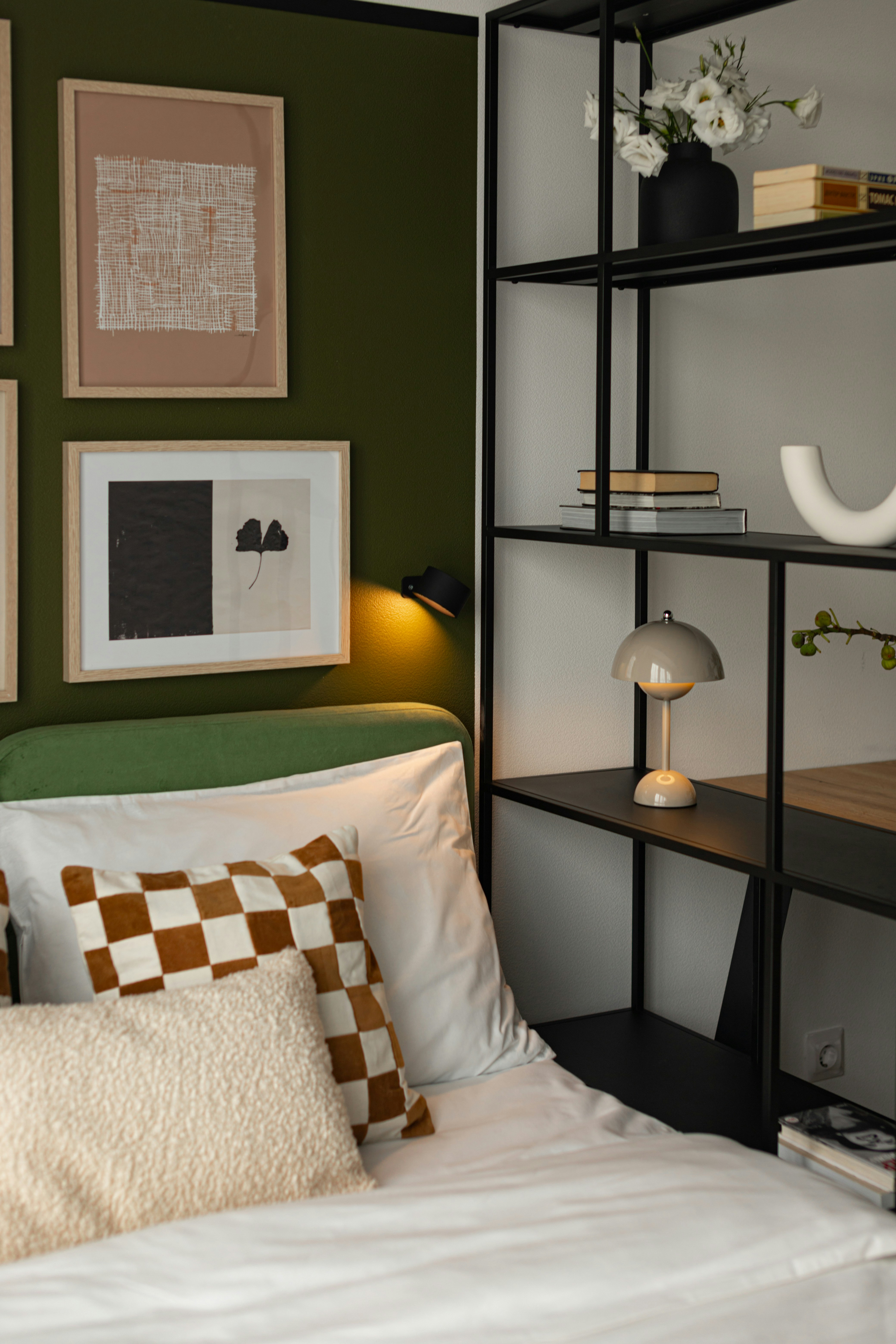 Modern bedroom with artwork and shelving unit.