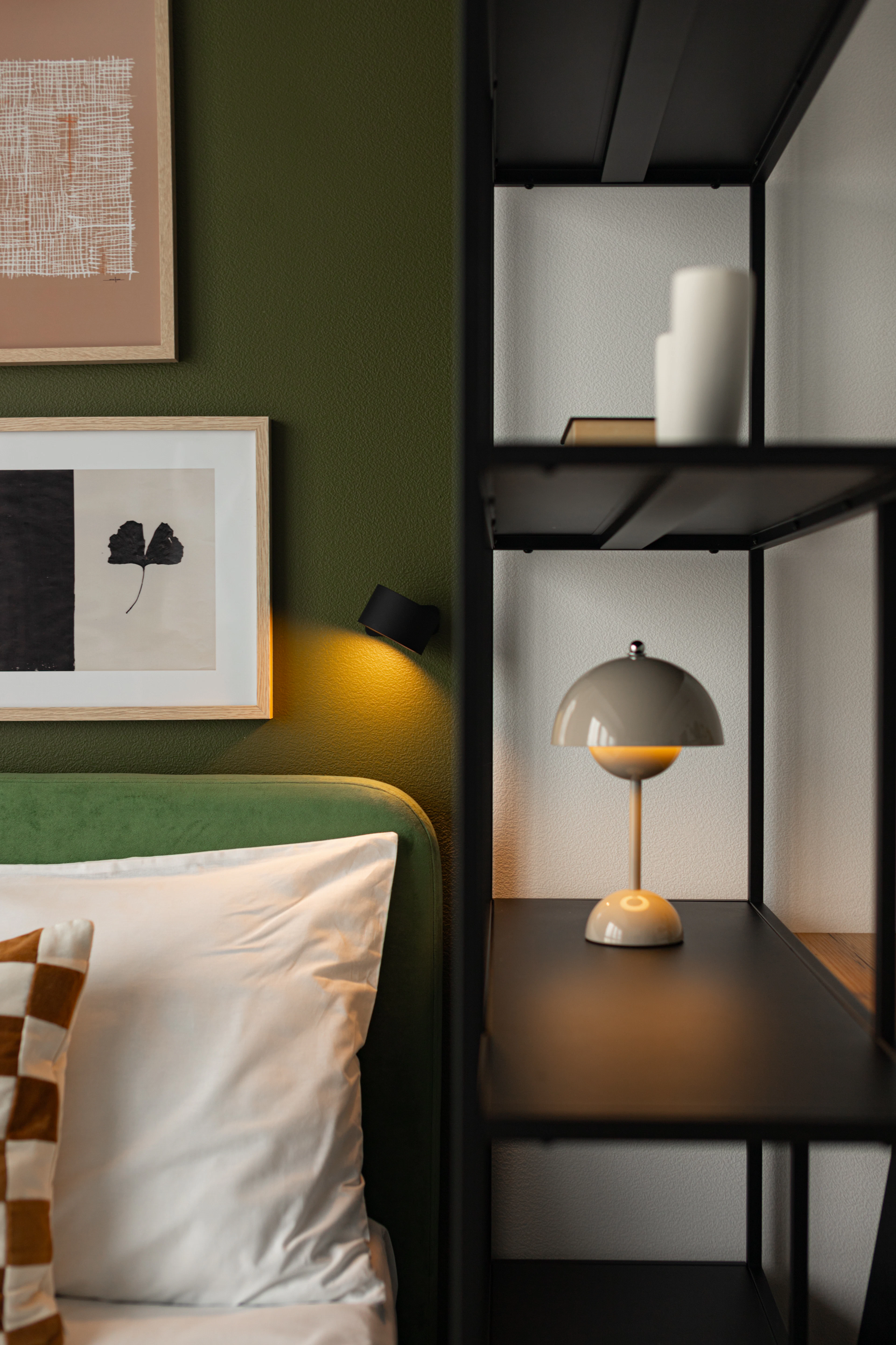 Bedroom with a green headboard and artwork