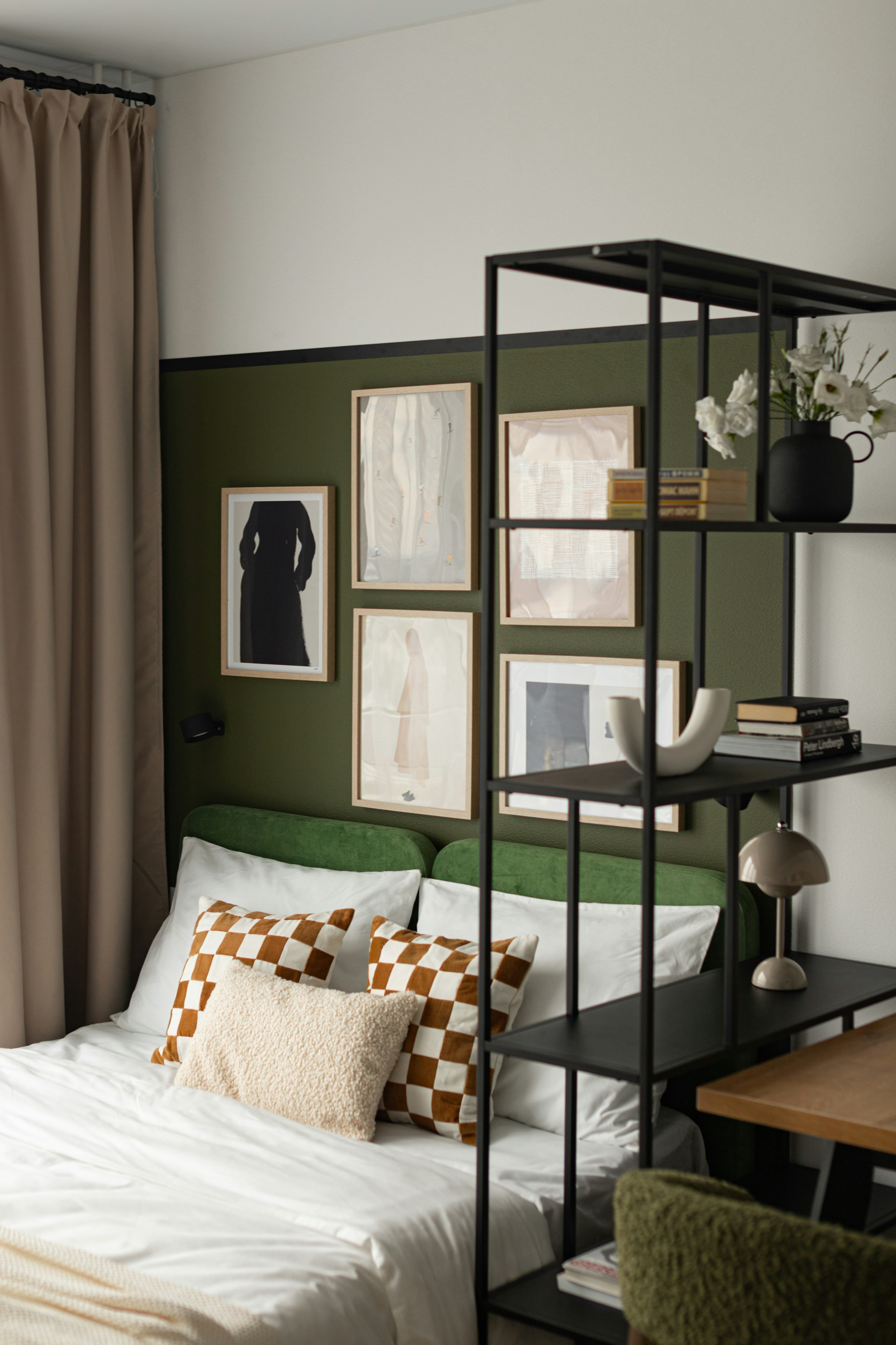 A modern bedroom with artwork and a black shelf.