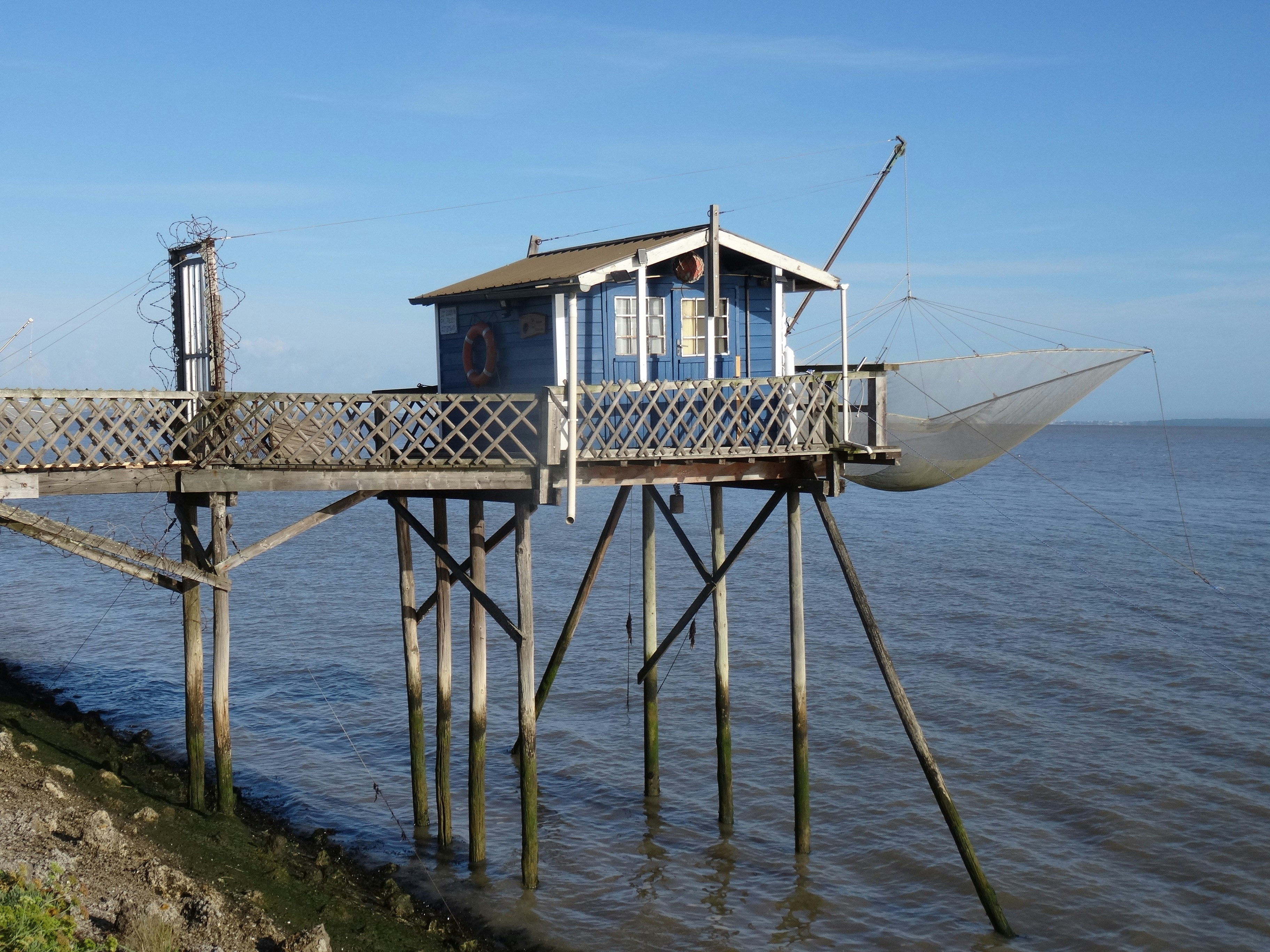 Blaue Fischerhütte auf Stelzen über dem Wasser