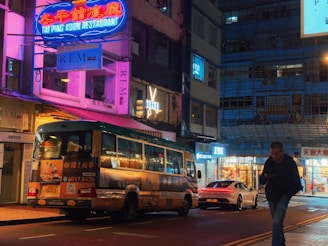 City street at night with bus and cars.