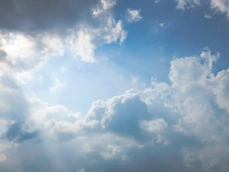 Sunlight breaking through dramatic clouds in a blue sky