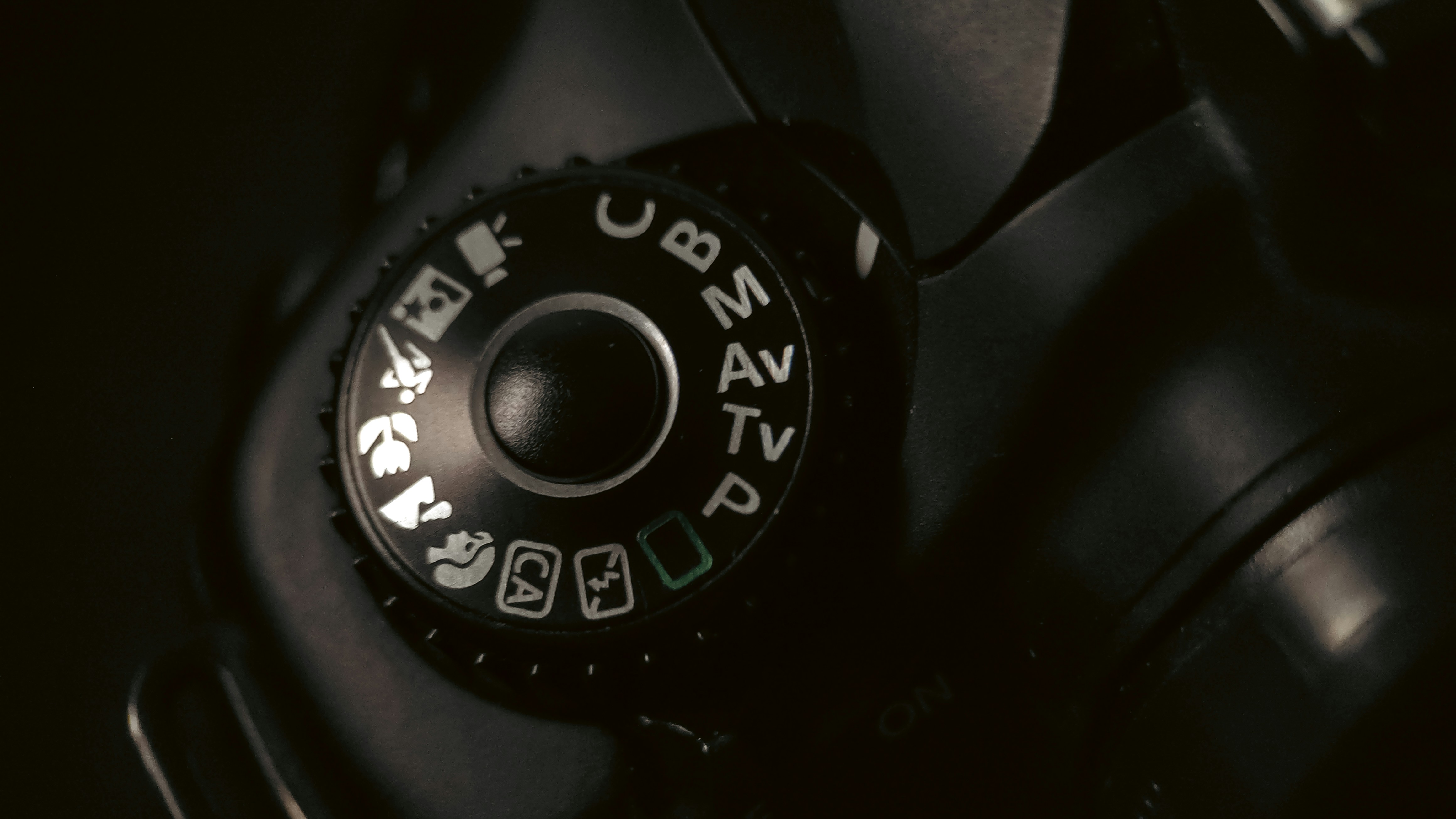 Nahaufnahme eines Kamera-Modus-Wahlrads mit Einstellungen.