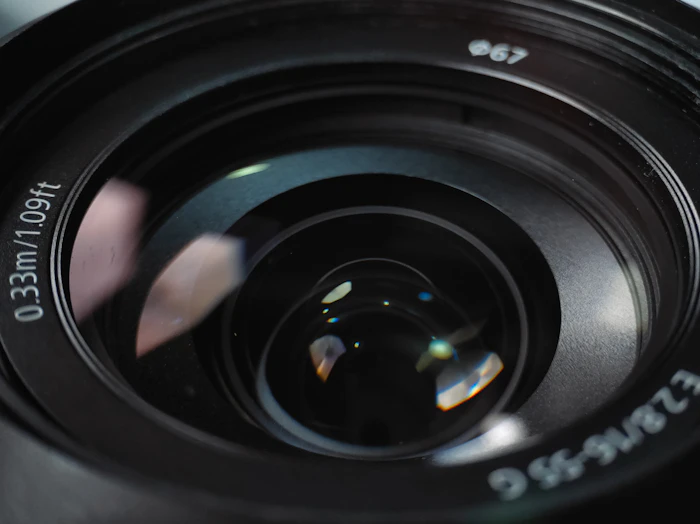 Close-up of a camera lens with coloured reflections