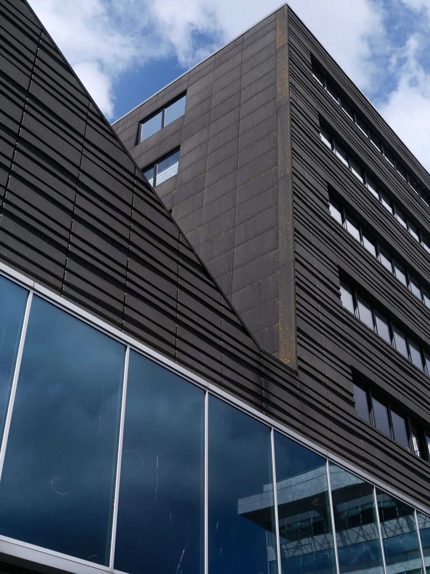A modern building wrapped in dark reflective glass.