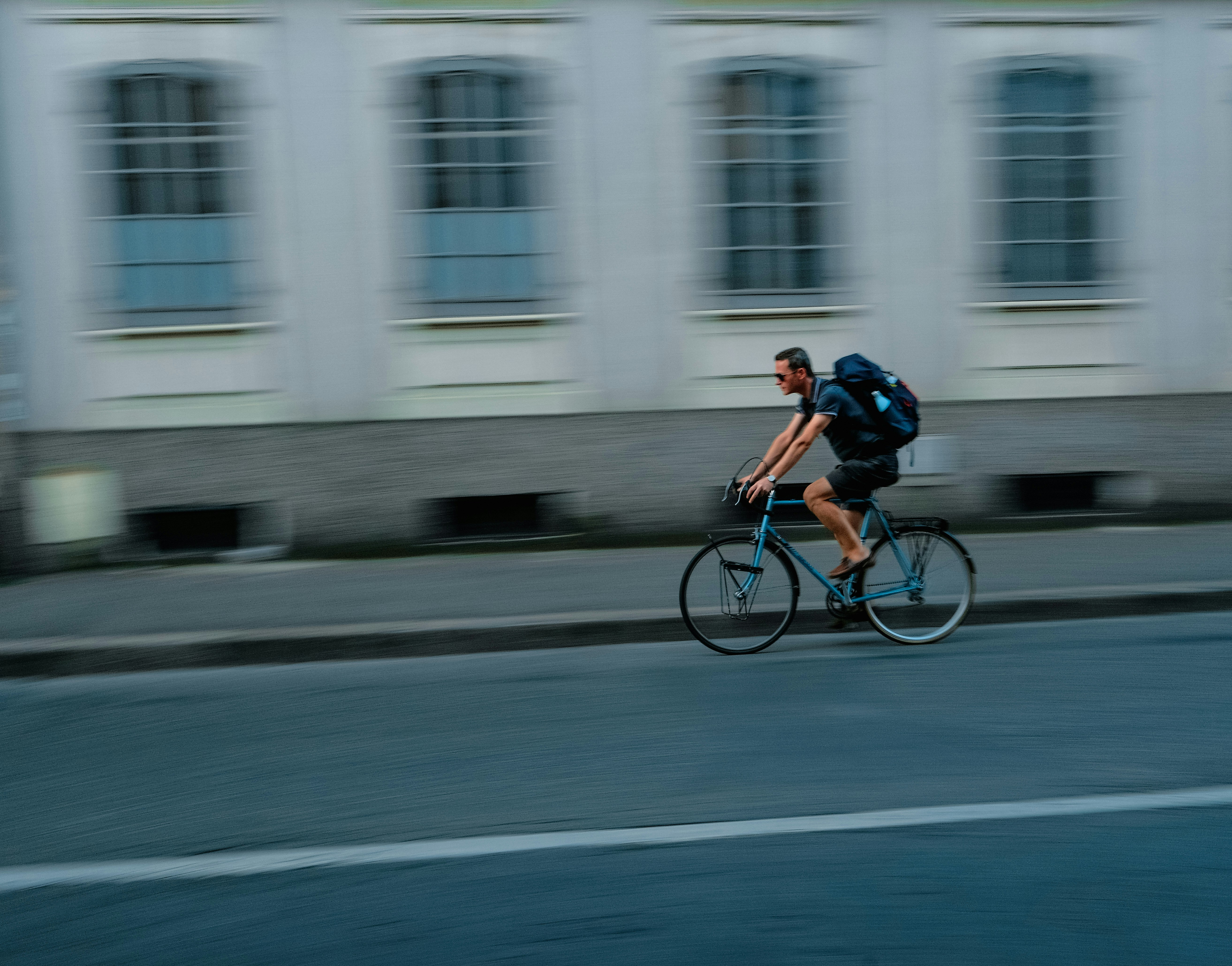 Man riding bicycle with backpack on street