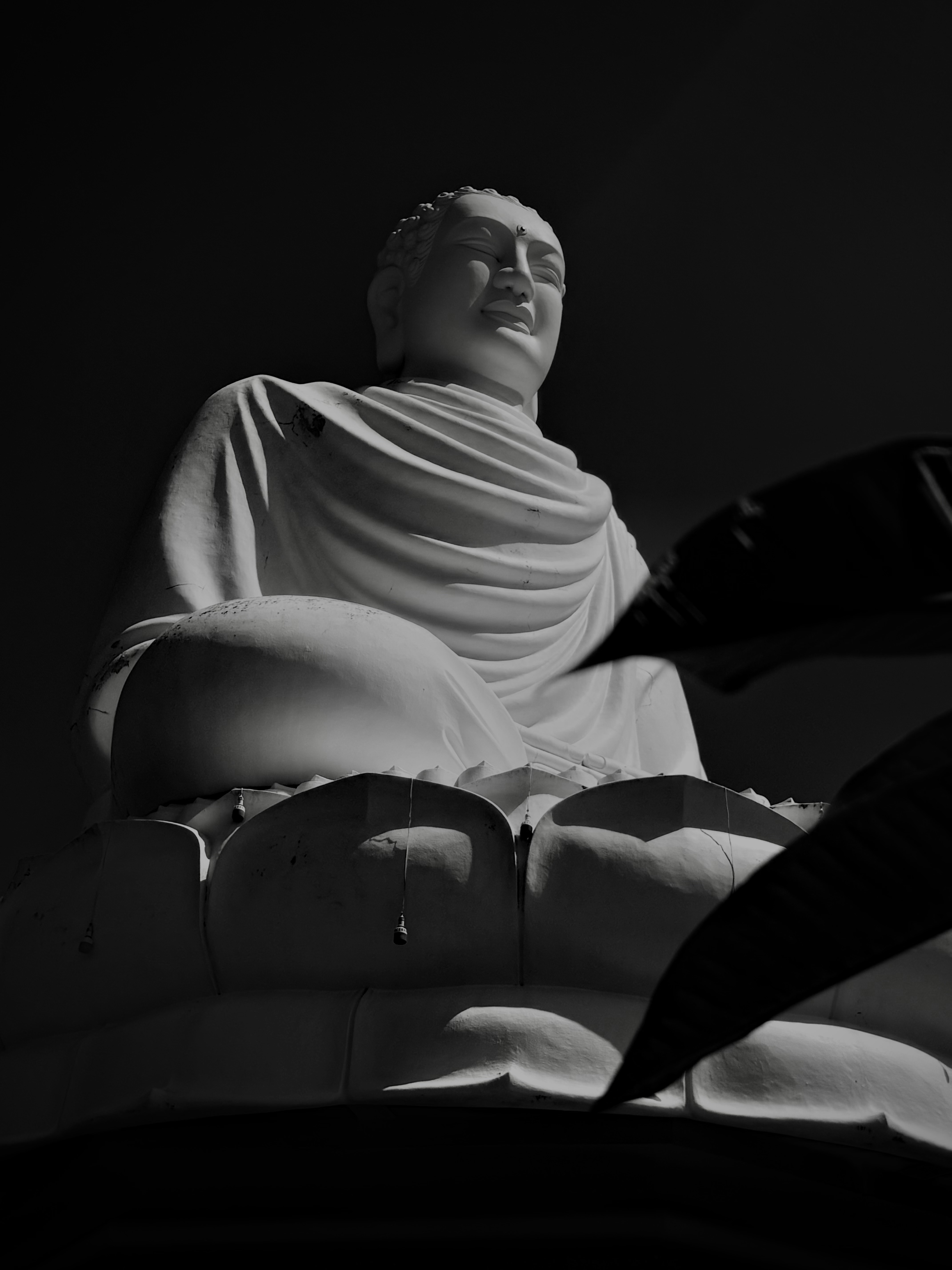 A serene white buddha statue sits serenely.
