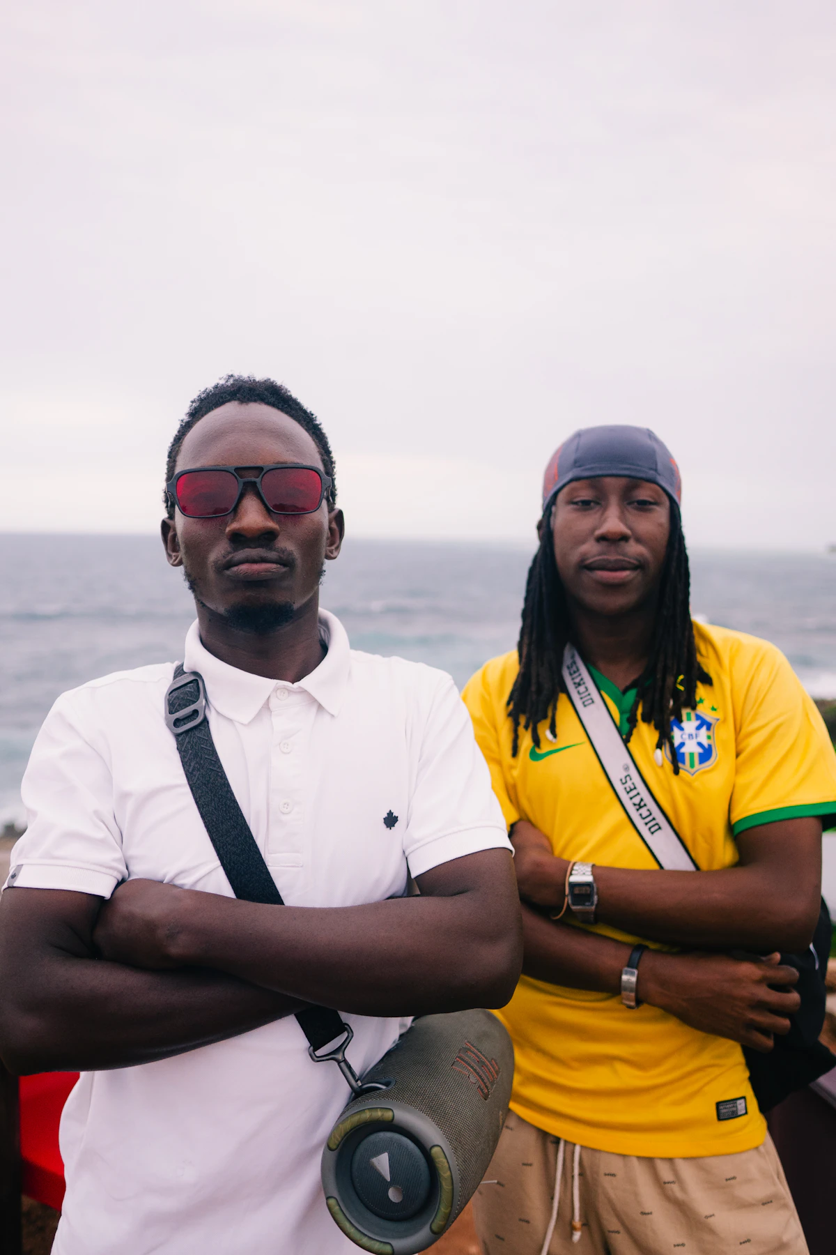 Two men posing with arms crossed outdoors
